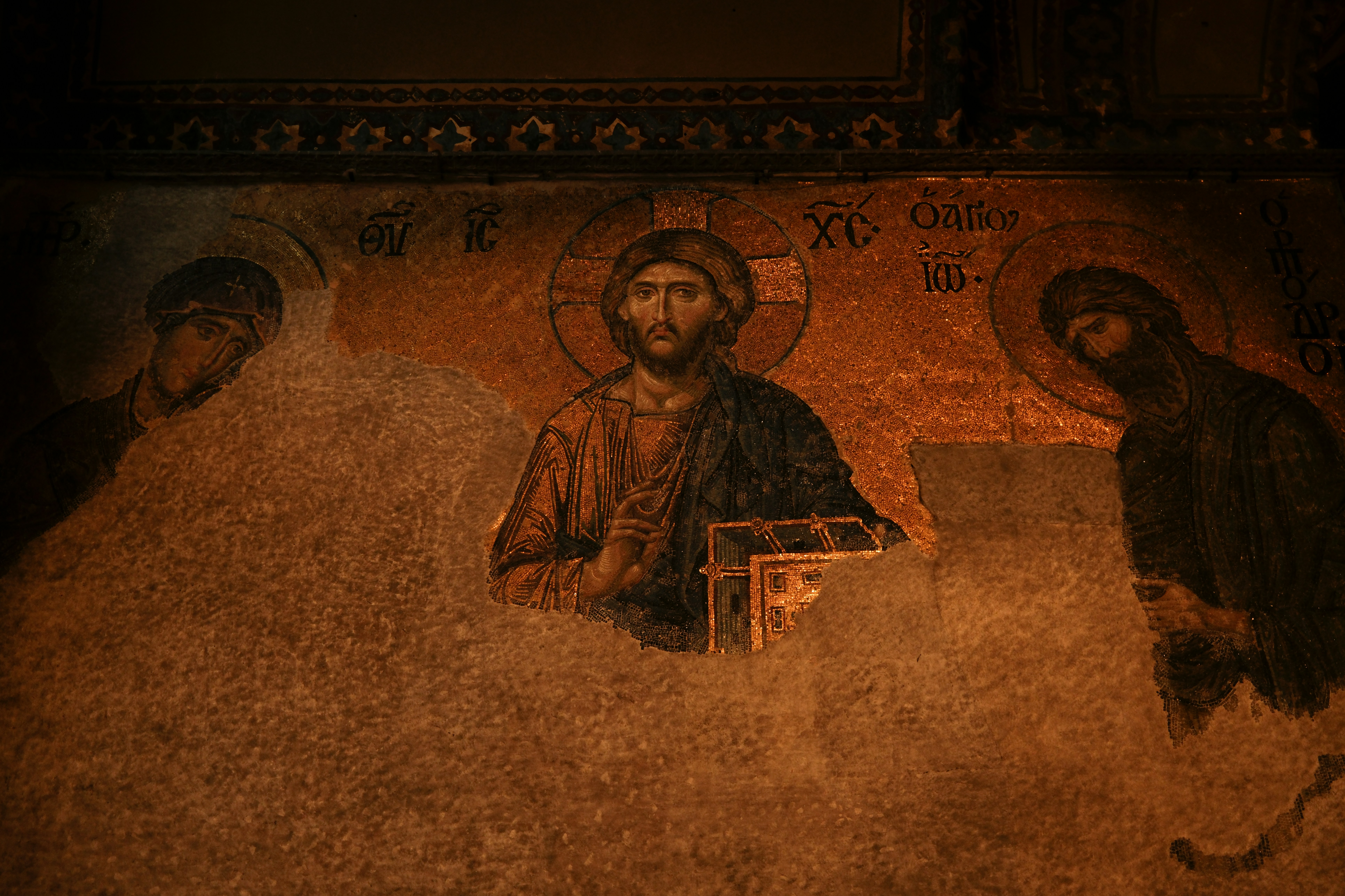 Ancient mosaic of jesus christ with two figures.