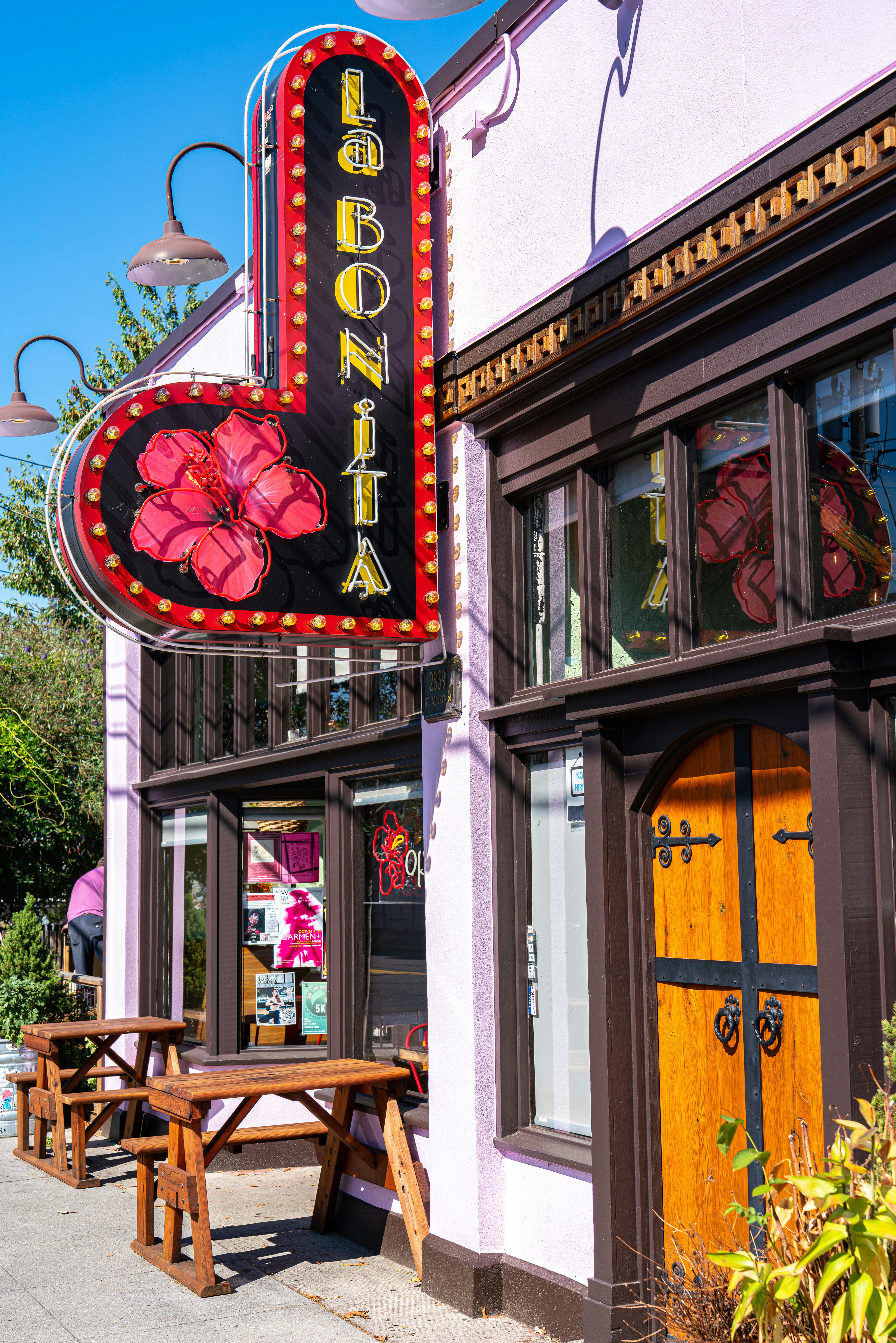 Placa La bonita acima dos assentos ao ar livre do café