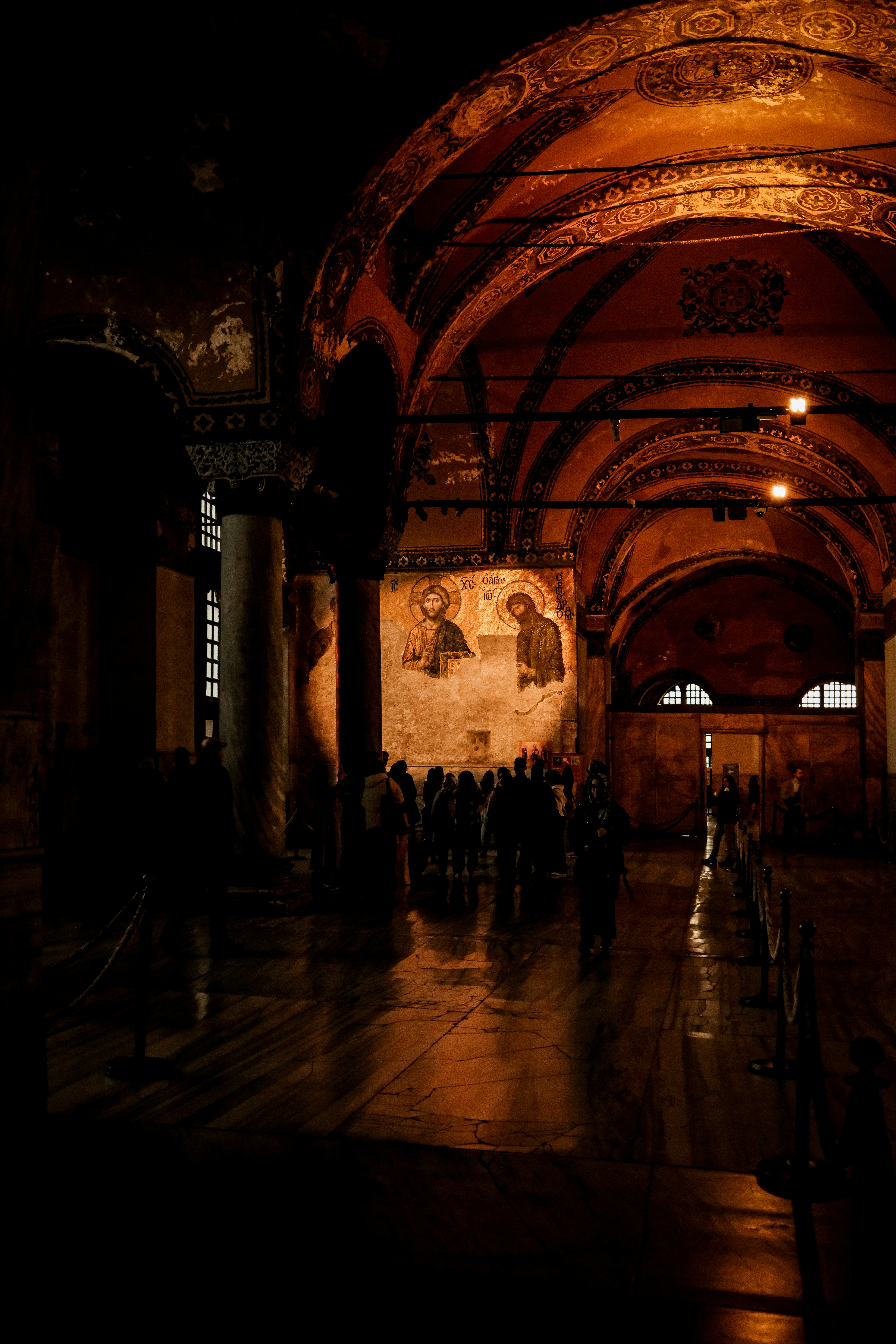 Dimly lit interior with arched ceilings and mosaics.