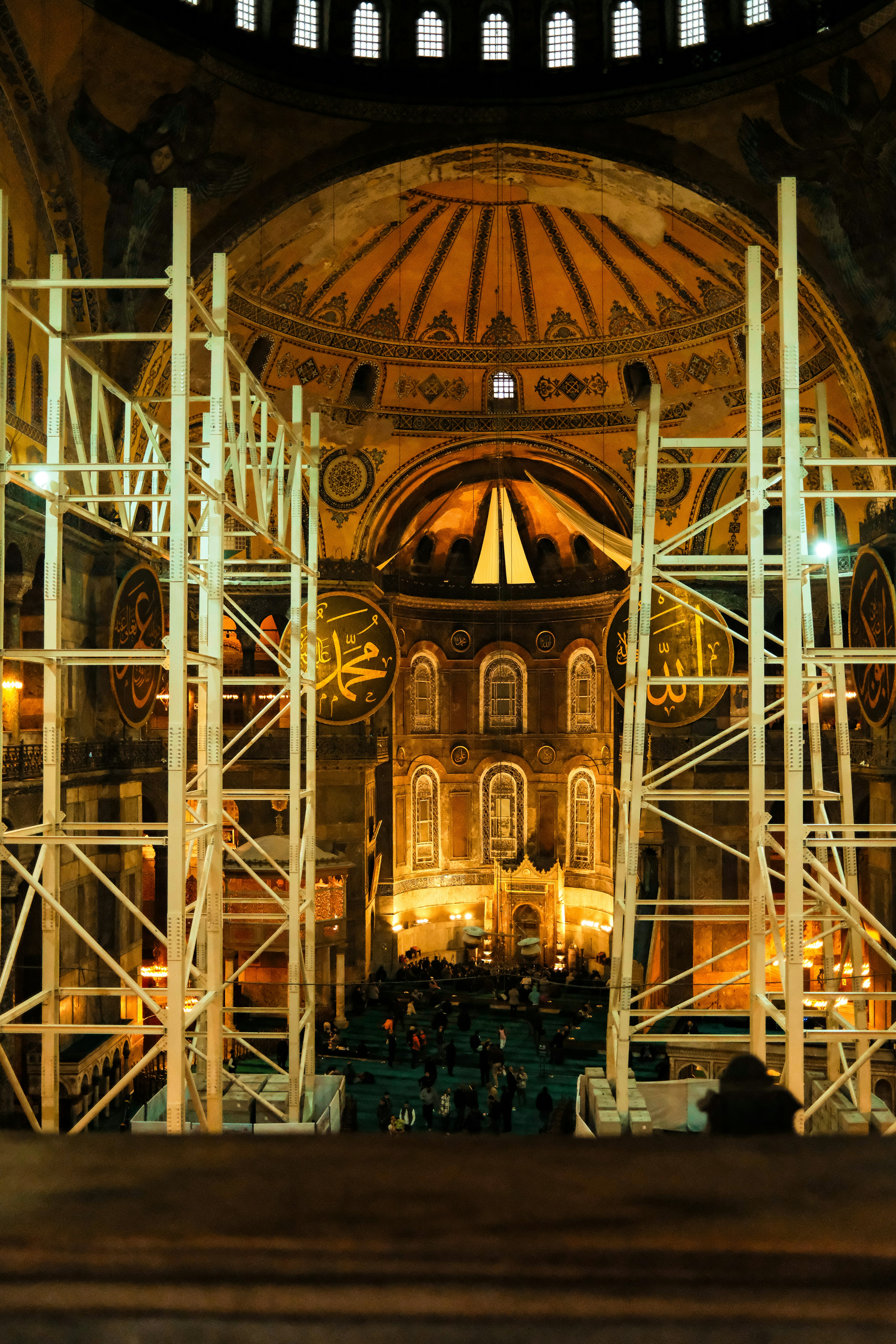 Interior of hagia sophia with scaffolding and people below.