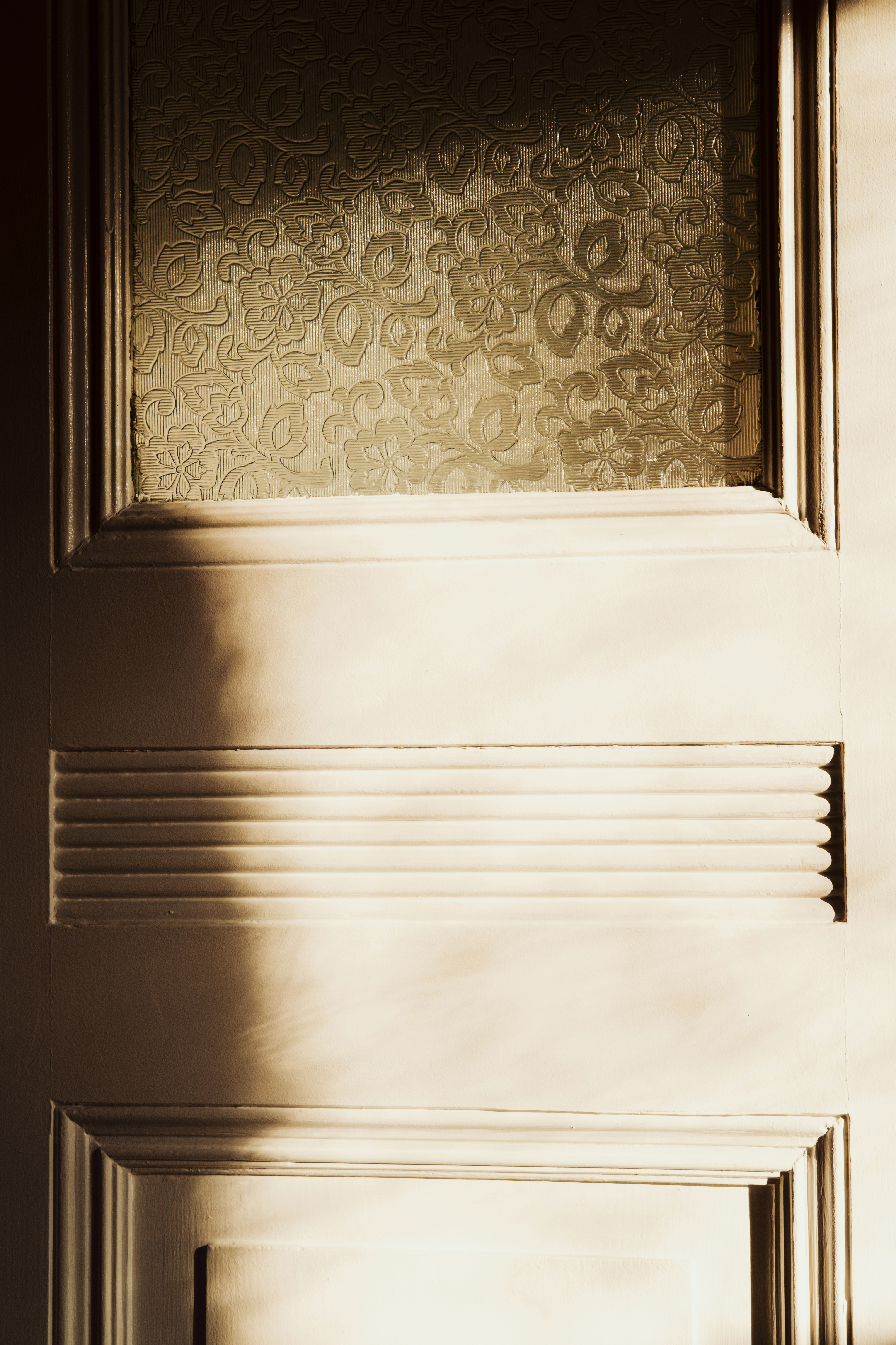 Gros plan d’une porte en bois avec un panneau de verre à motifs