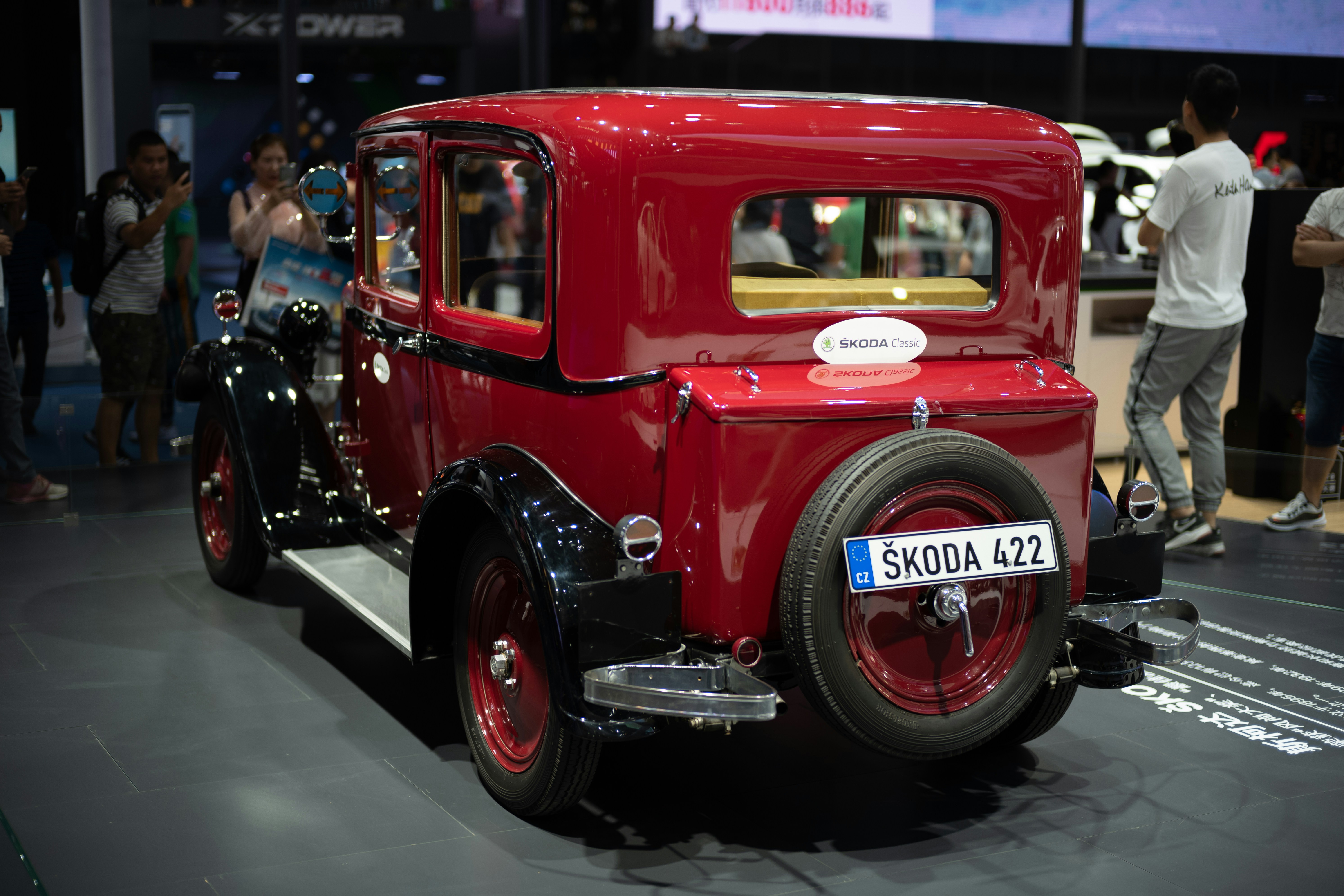 Vintage red skoda car with spare tire on back.