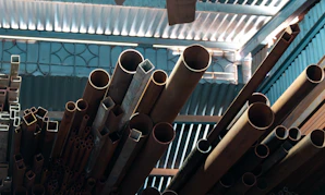 Metal pipes and tubes stacked indoors.