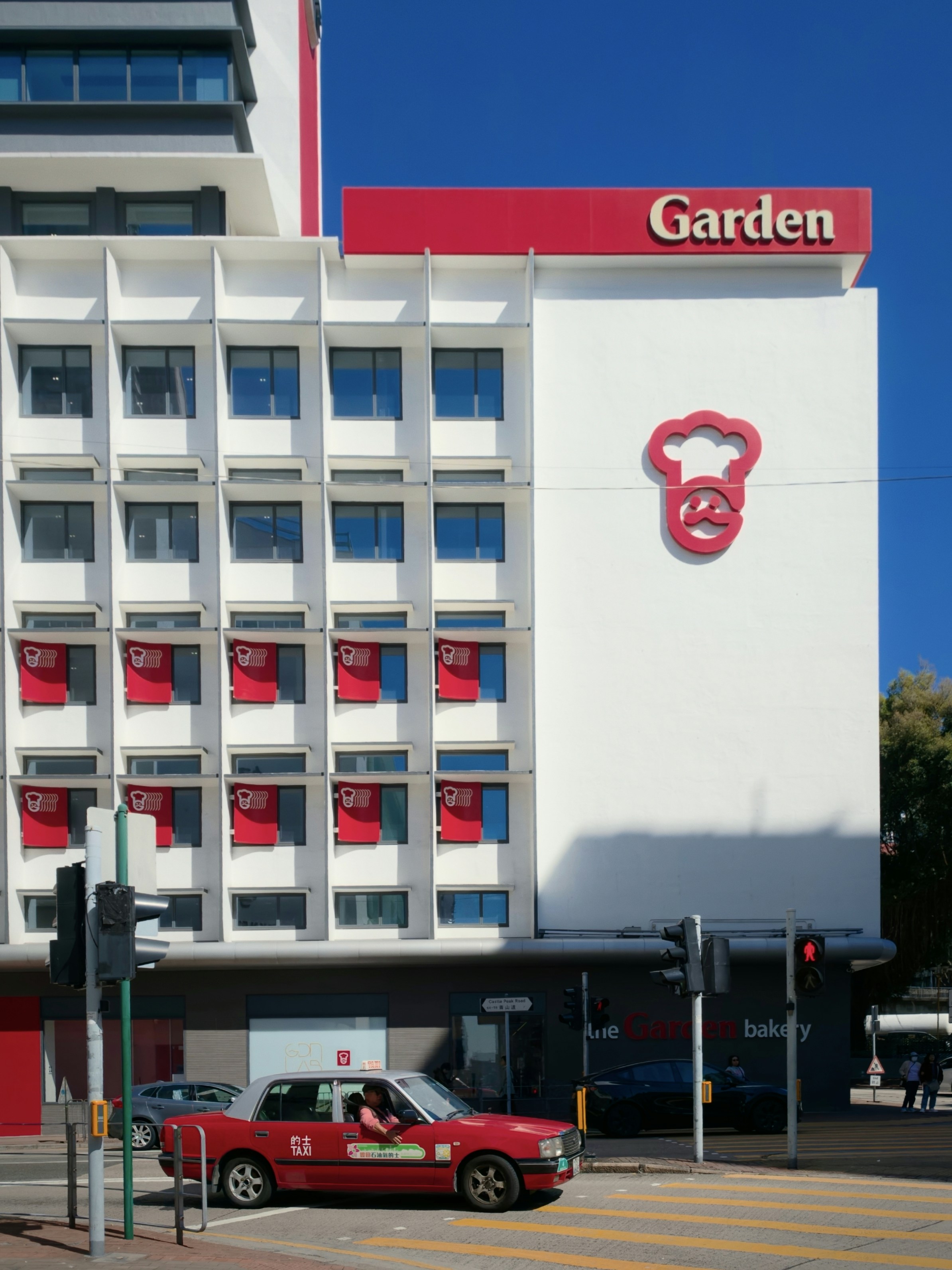 Modern building with red accents and a taxi.
