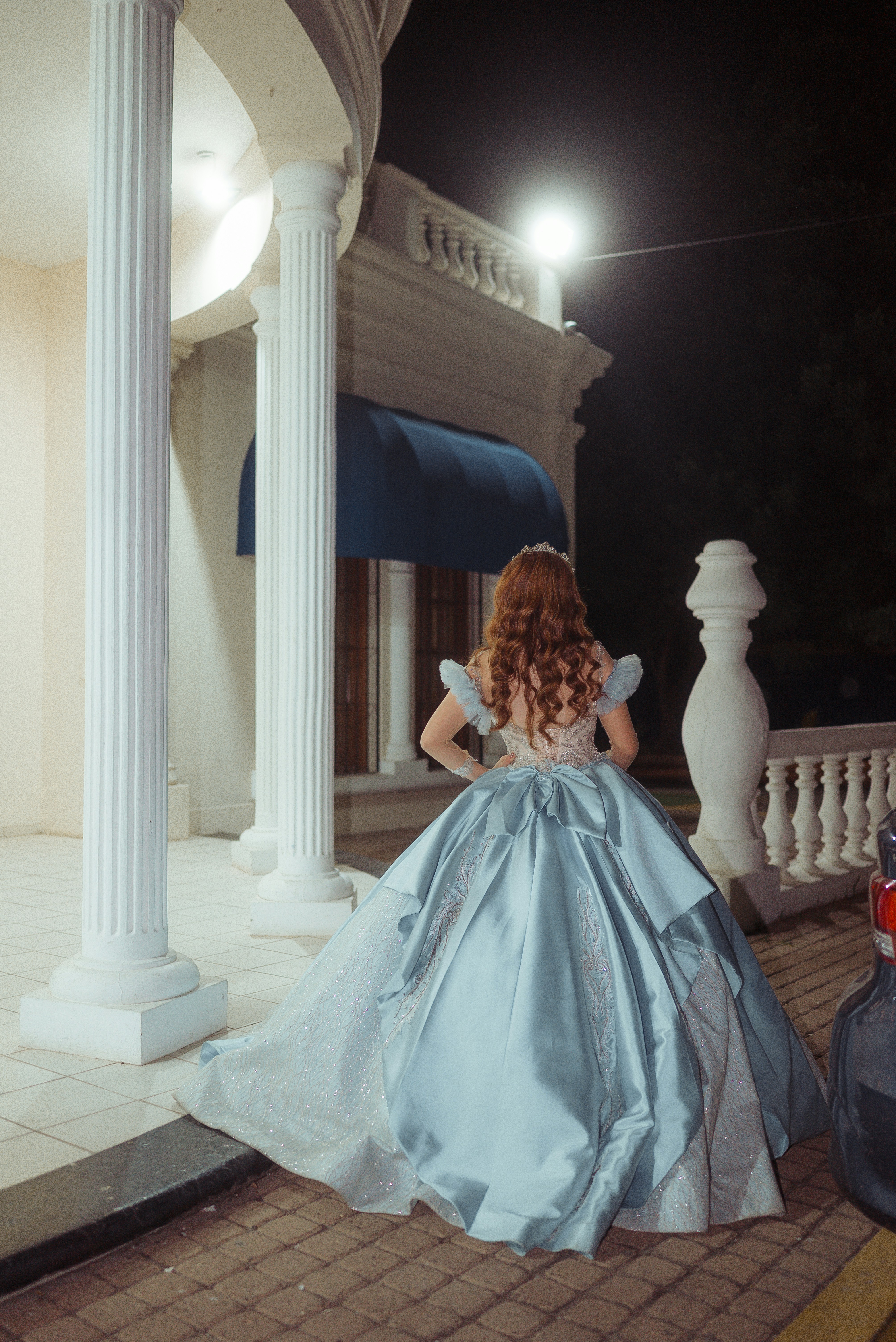 Woman in a light blue ballgown at night