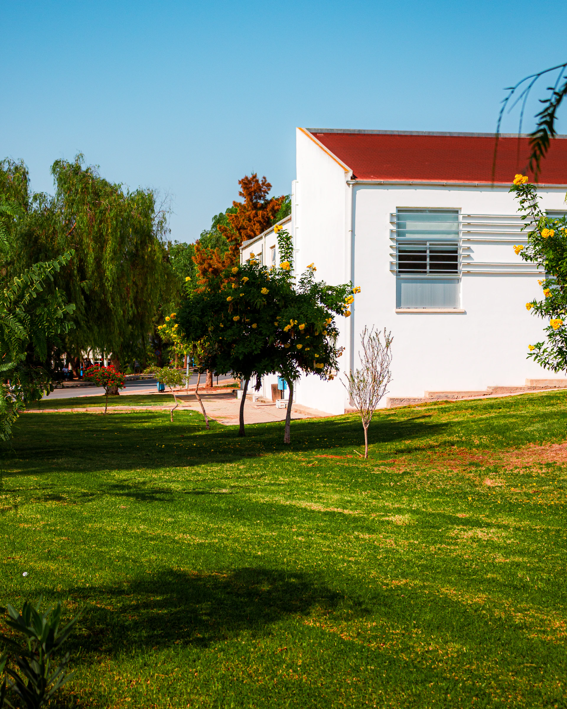 White building with red roof and green lawn