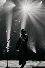 Musician playing guitar on stage with spotlights