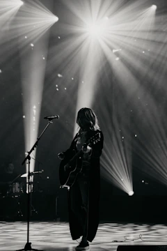 Musician playing guitar on stage with spotlights