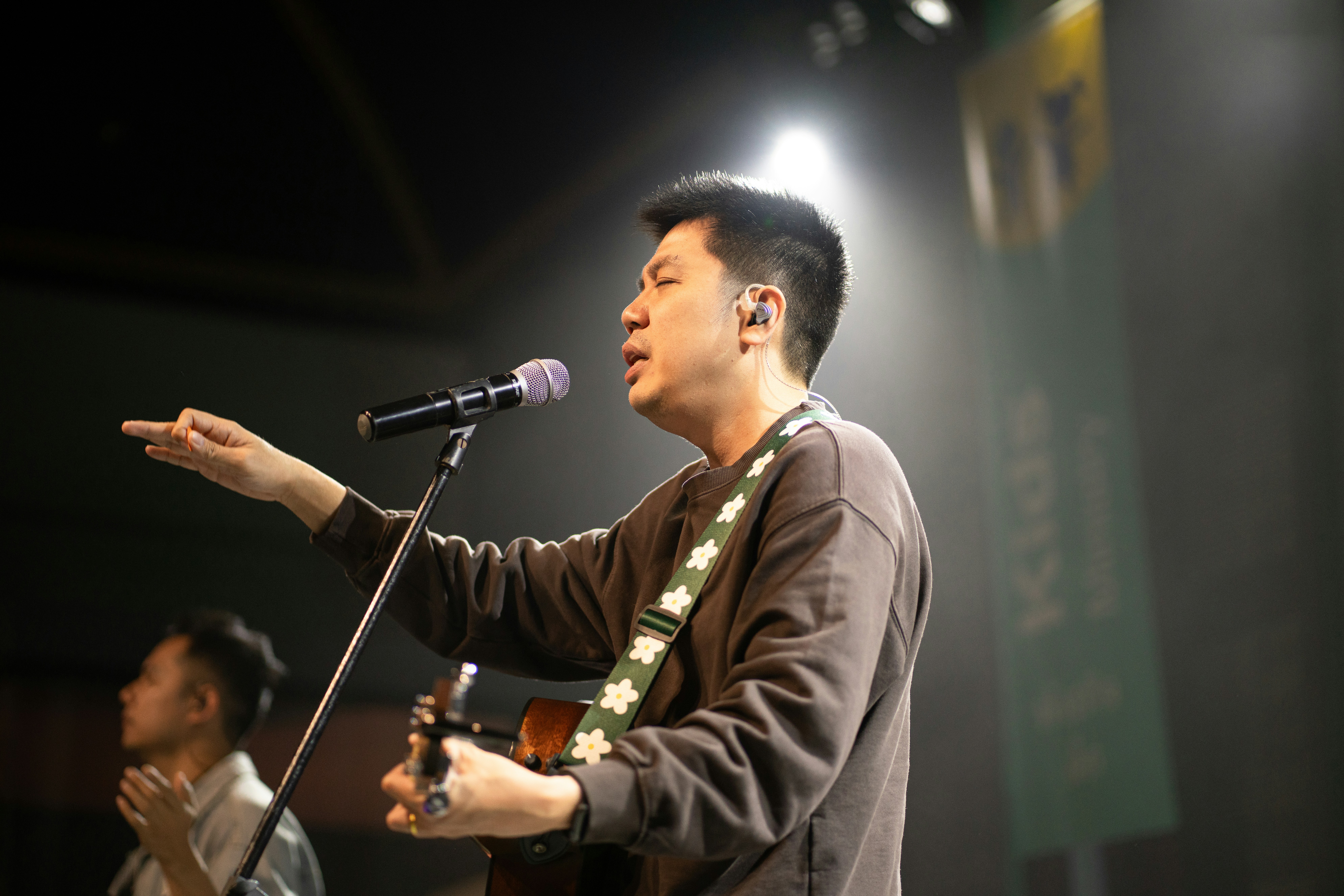 Man singing and playing guitar on stage