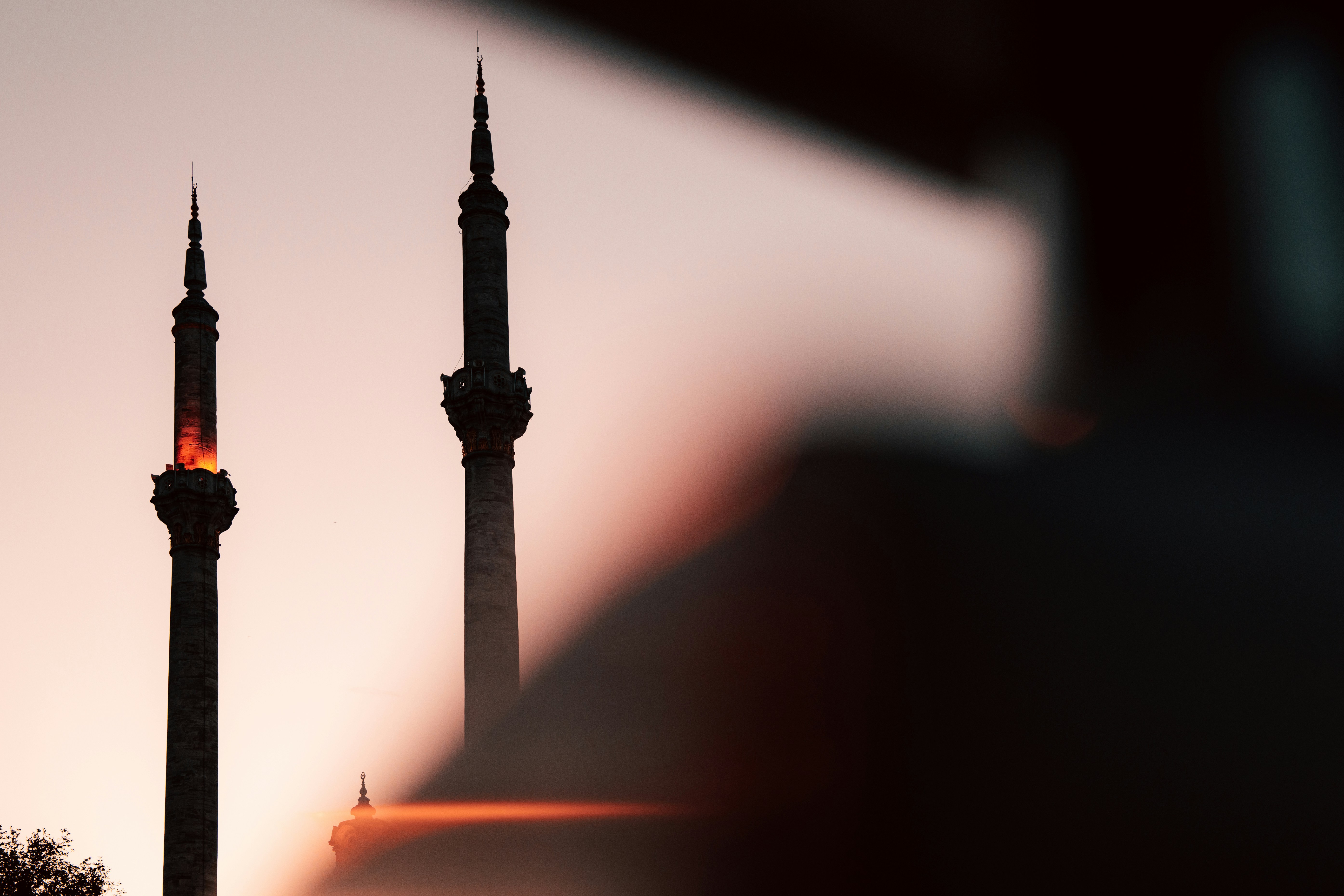 Two minarets silhouetted against a sunset sky.