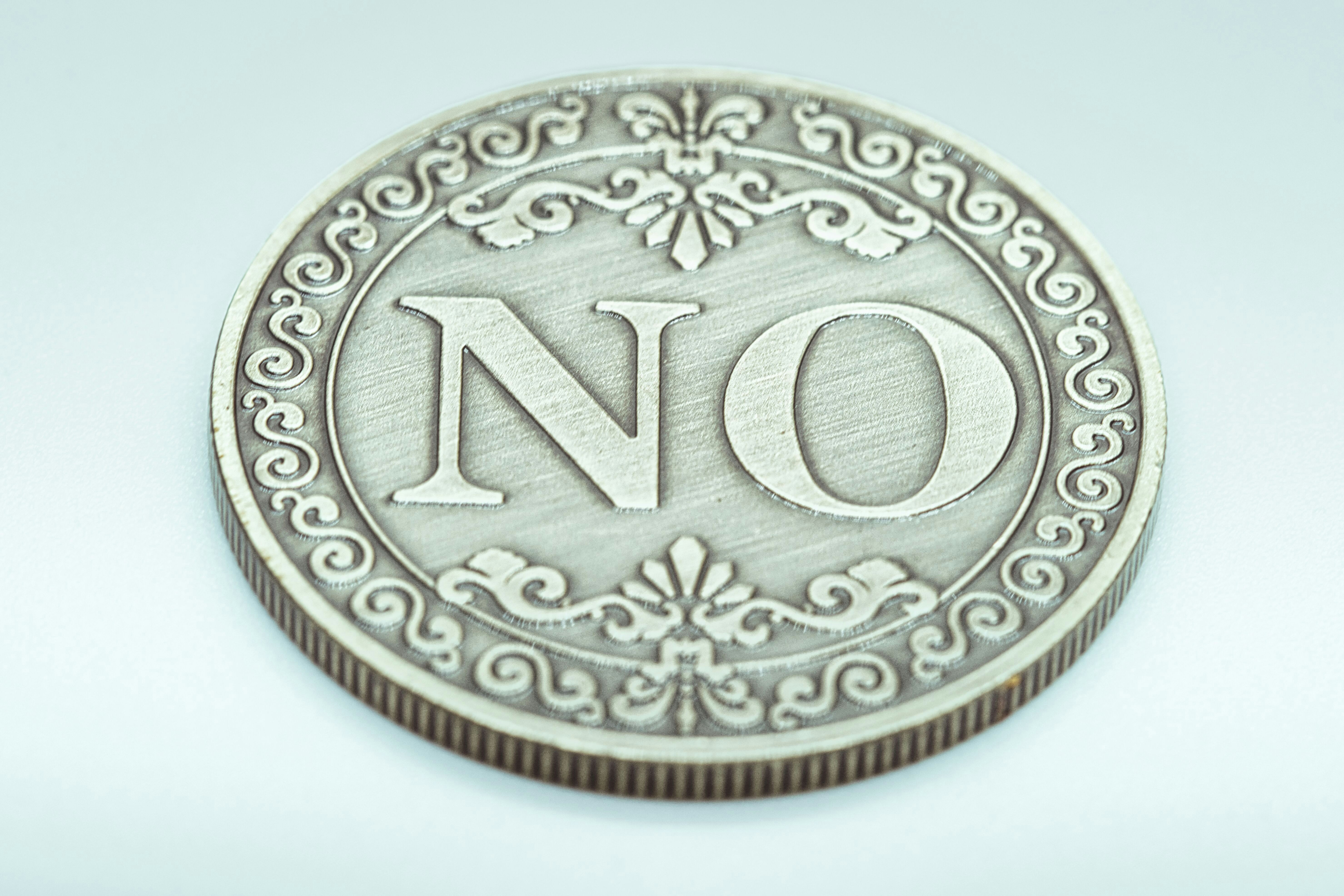 A decorative coin with the word no