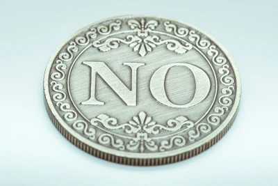 A decorative coin with the word no