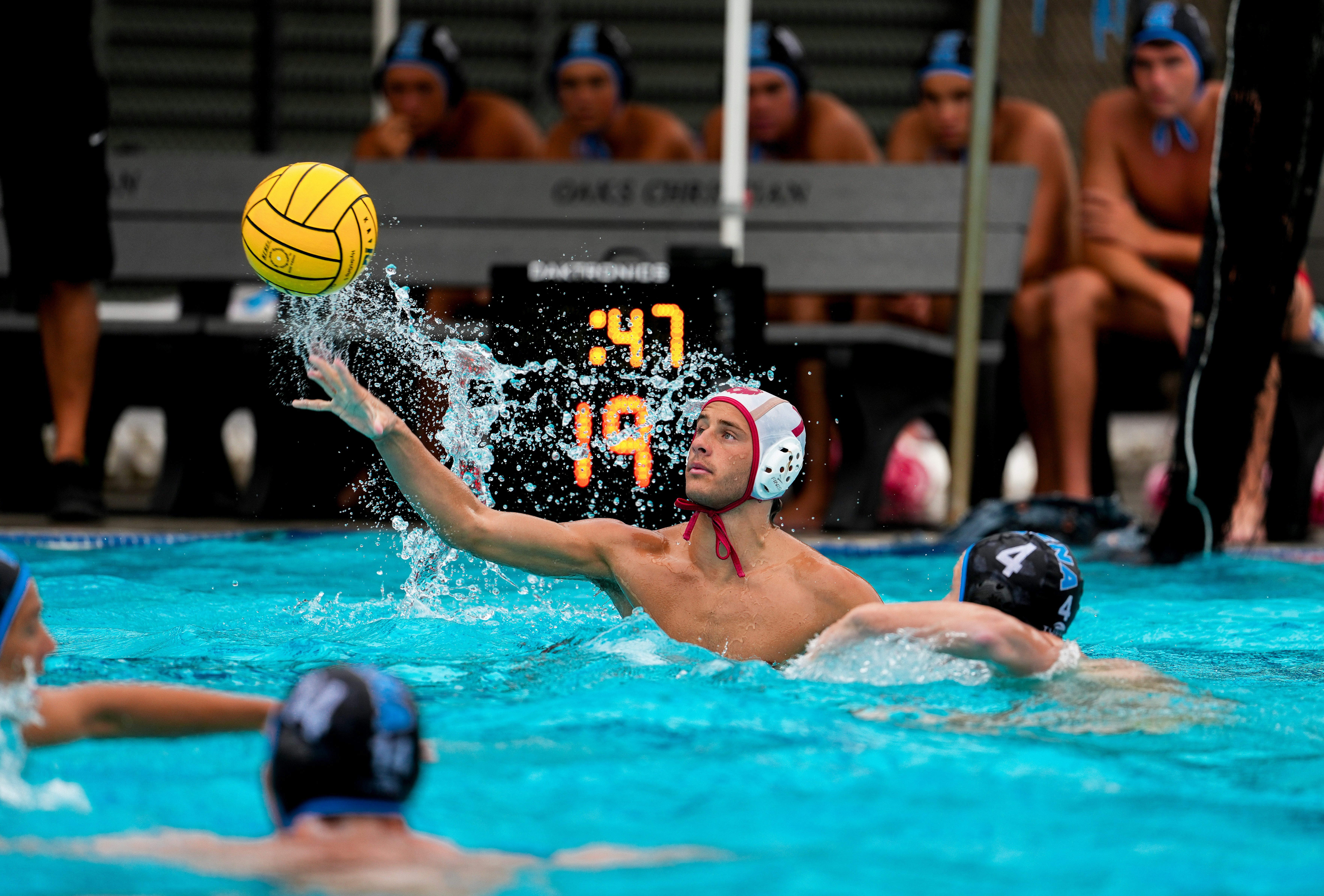 Water polo player throws ball during game.
