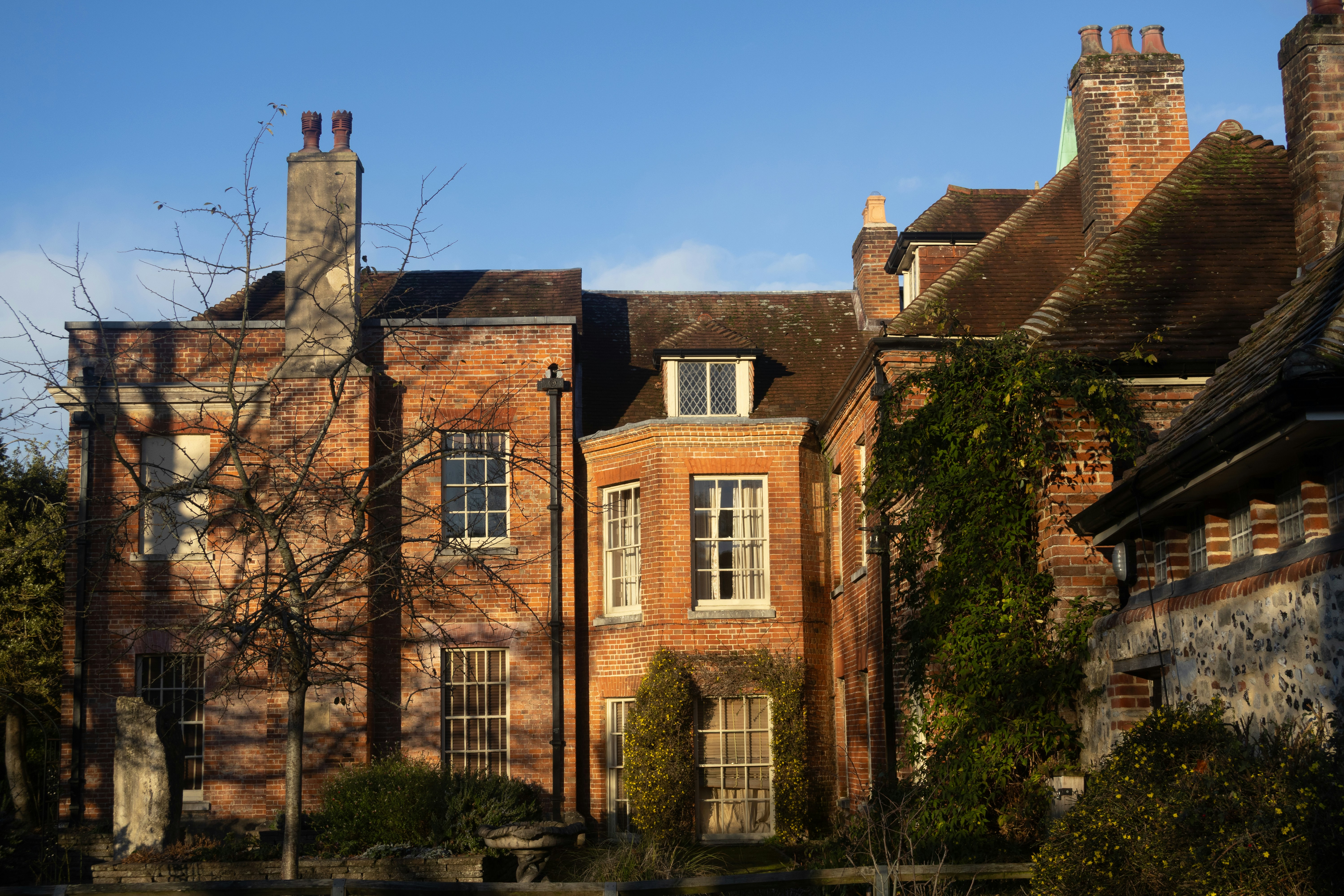 Historic brick building with tall chimneys under blue sky
