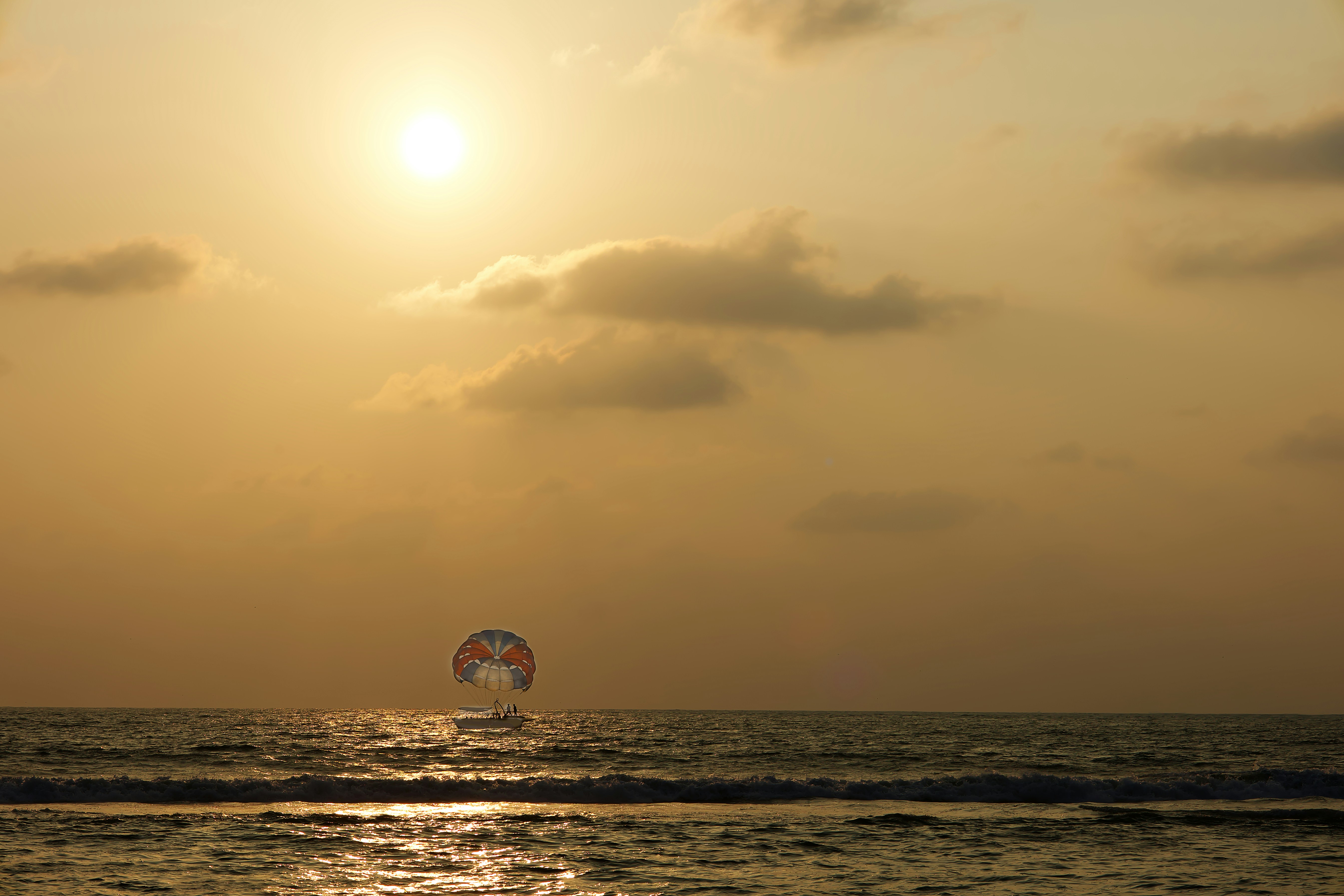 Parasailing at sunset over the ocean.