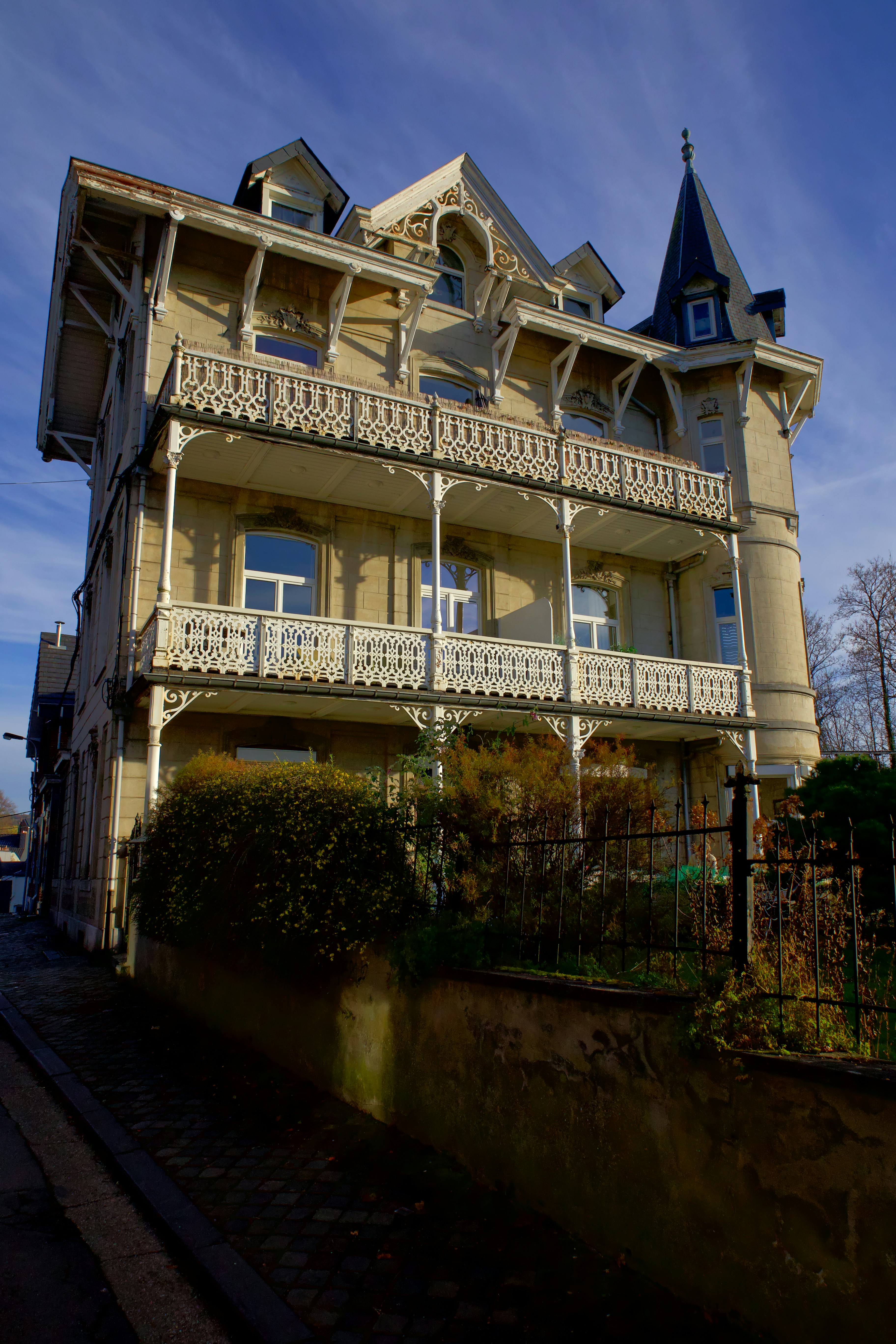 Ornate victorian house with balconies and turret.