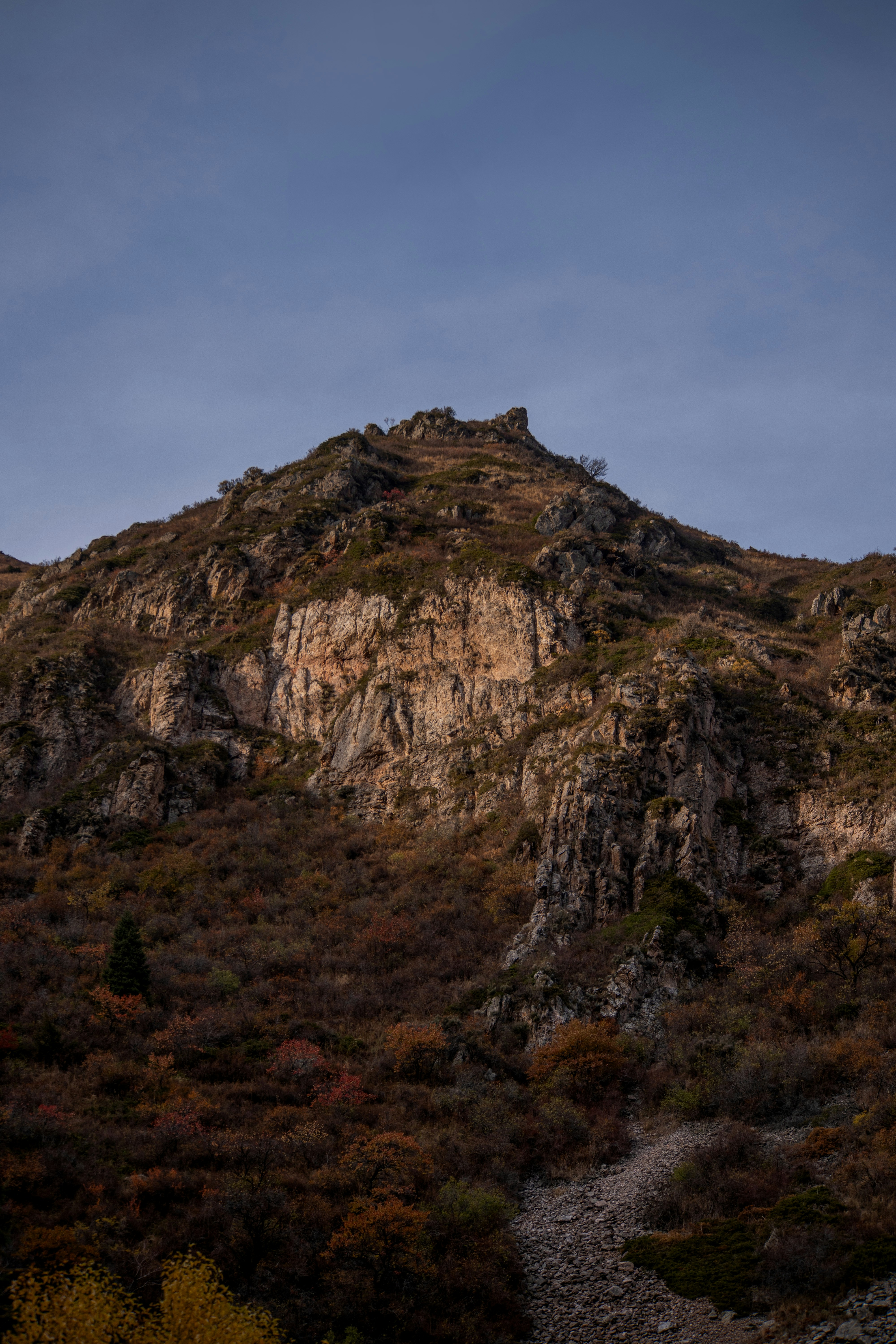 Rugged mountain peak with autumn foliage below