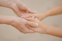 Two hands gently holding each other