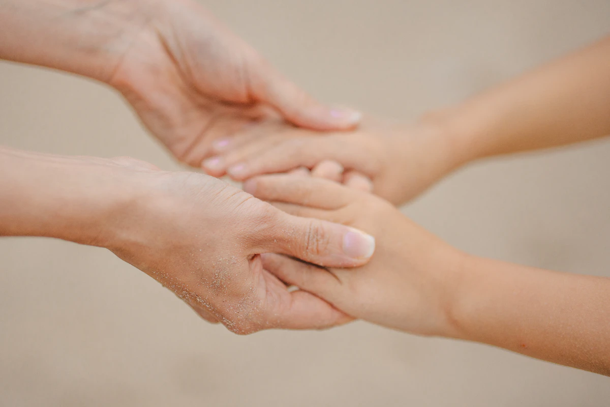 Tangan ibu dan anak yang saling menggenggam tanpa menampilkan wajah