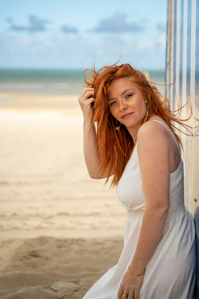 Woman with red hair on a sandy beach.