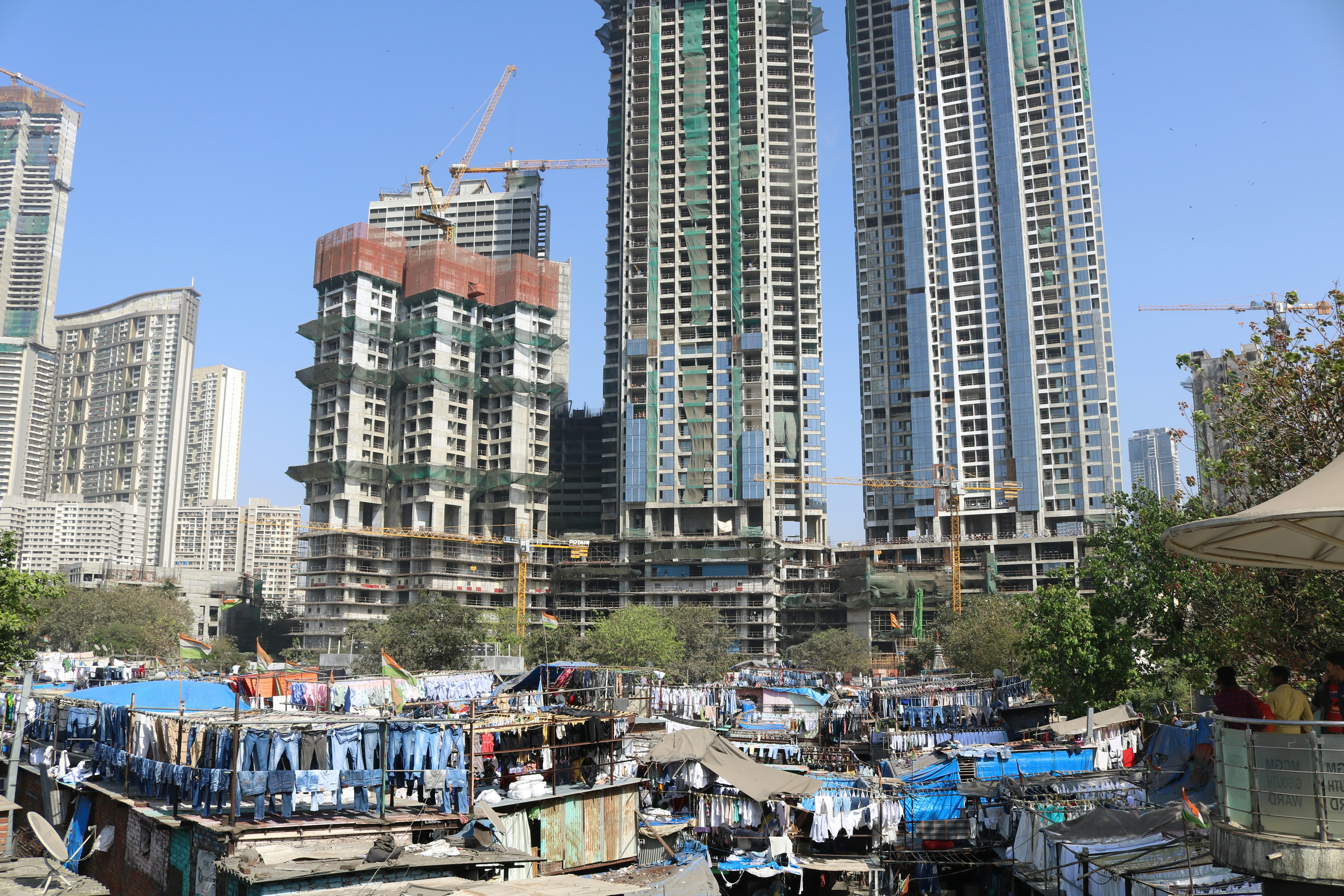Apartment buildings under construction next to a slum.