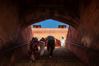 People ascend stairs towards ancient architecture