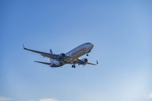 A commercial airplane flying in a clear blue sky.