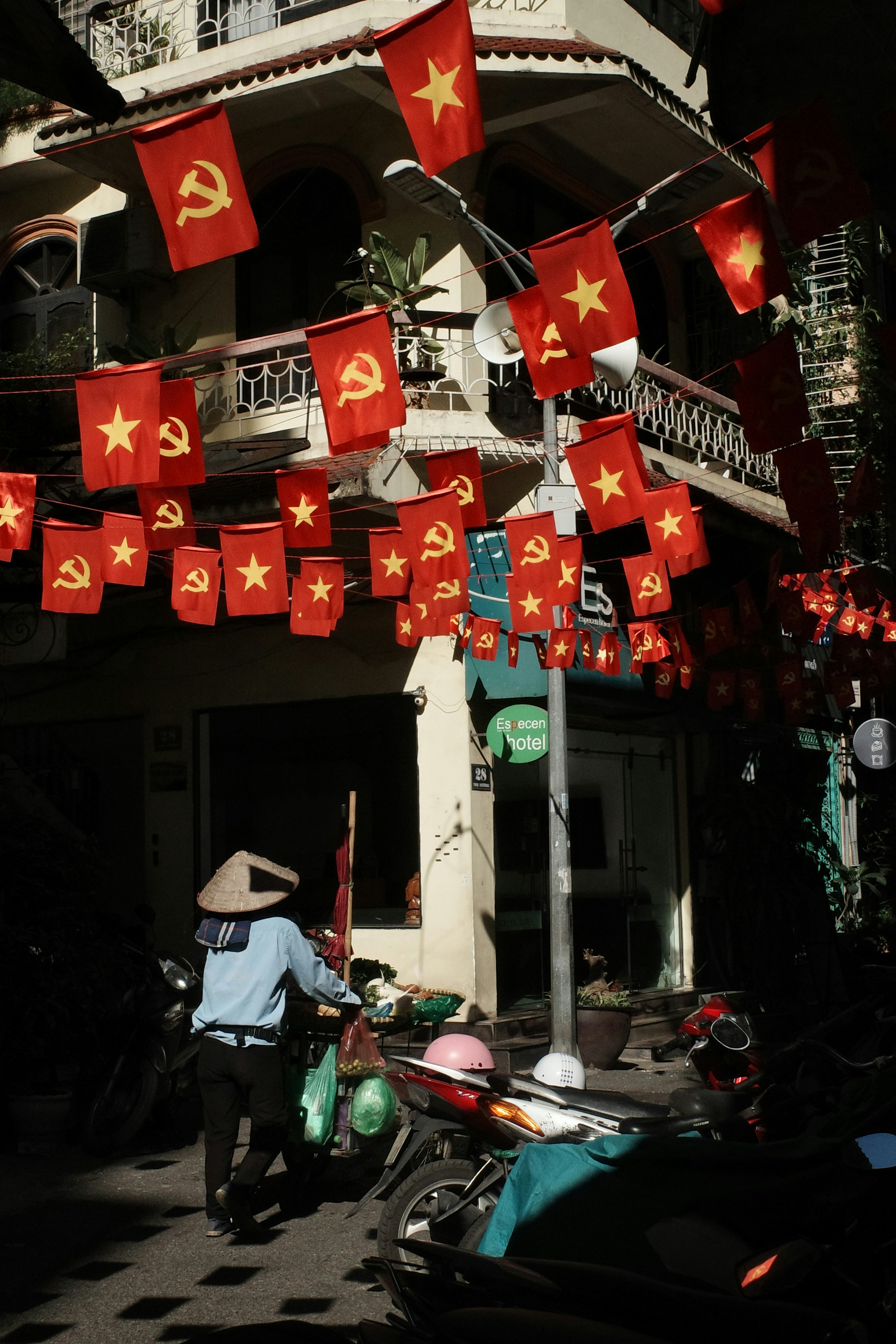 Person in conical hat with flags hanging overhead