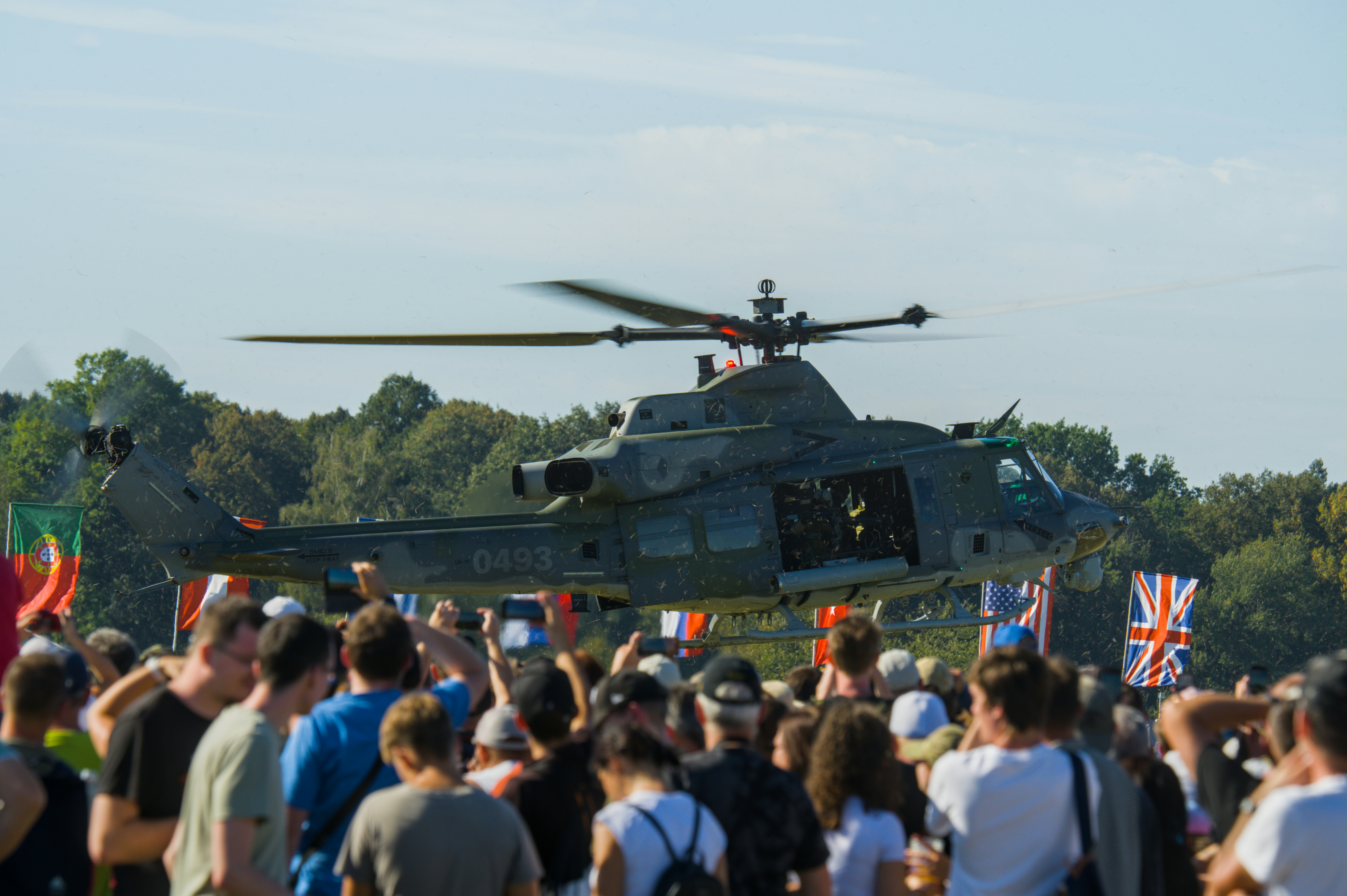 Helicopter flying over a crowd with flags