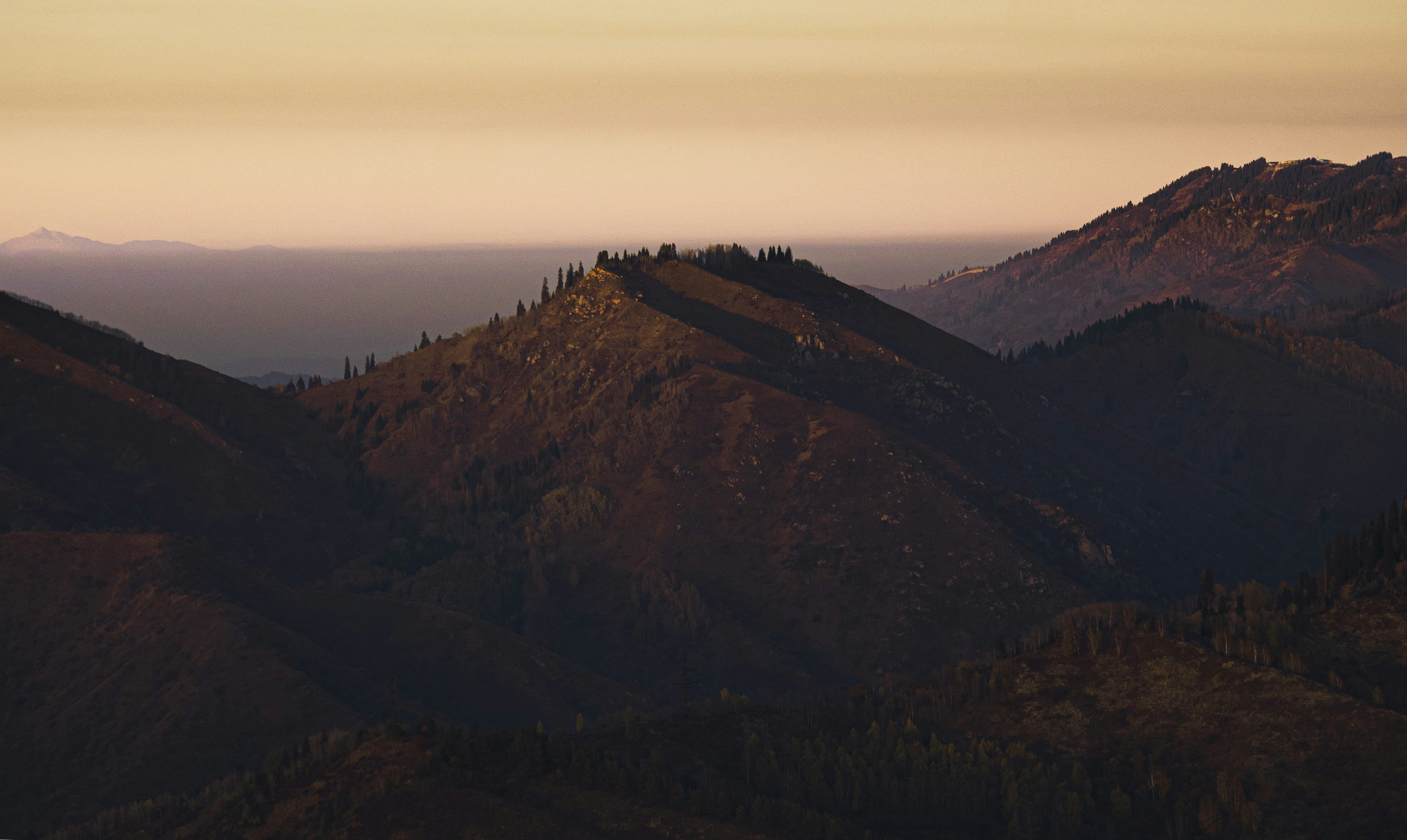 Mountain peaks at sunset with warm sky