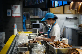 A person working behind a food counter.