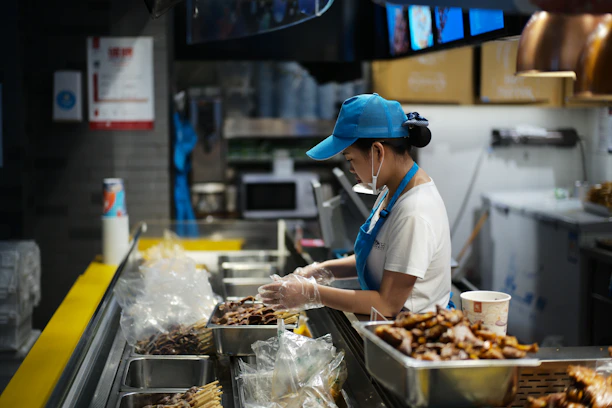 A person working behind a food counter.