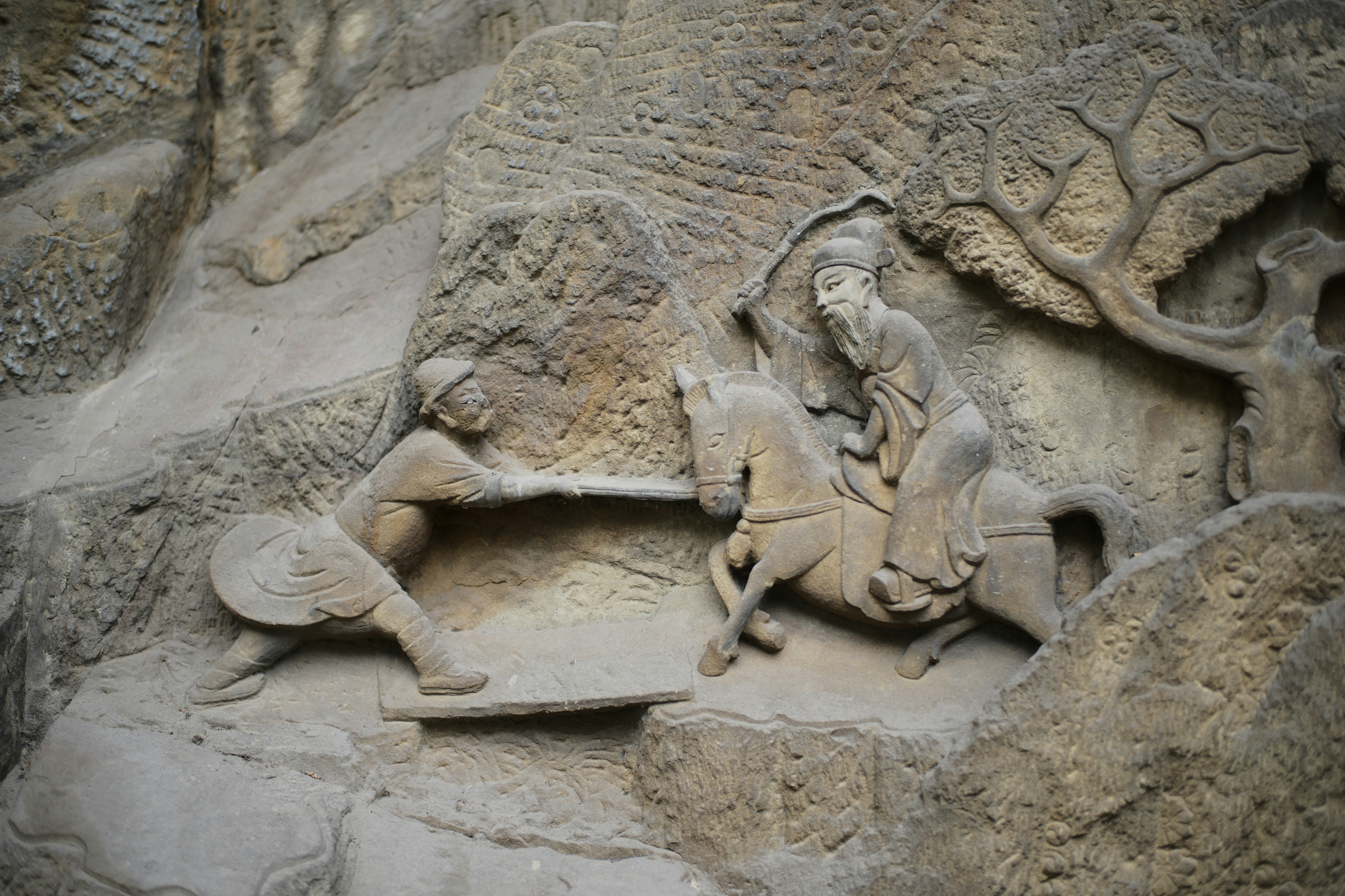 Ancient stone carving of figures on horseback