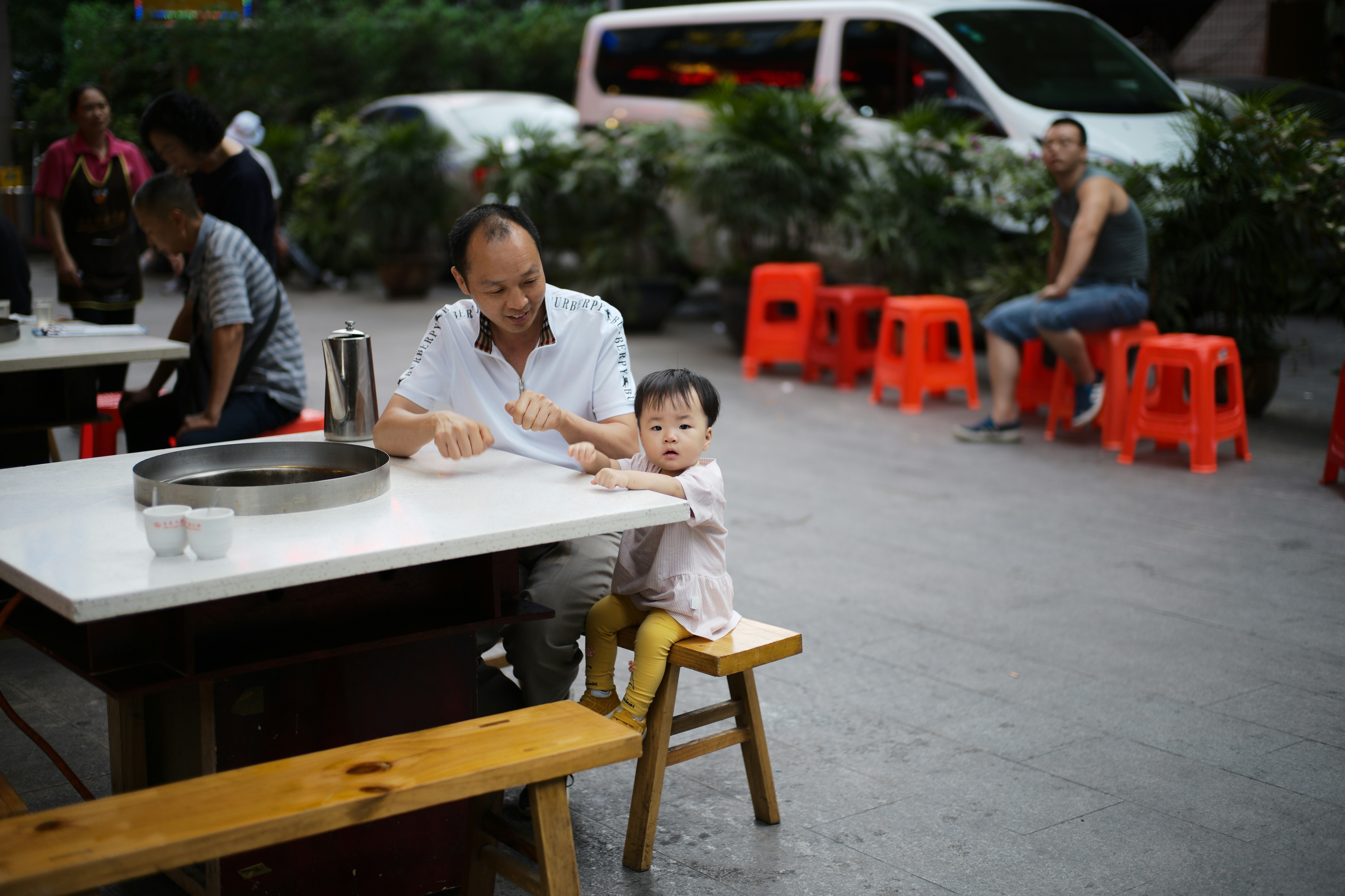A father and child eating at an outdoor table
