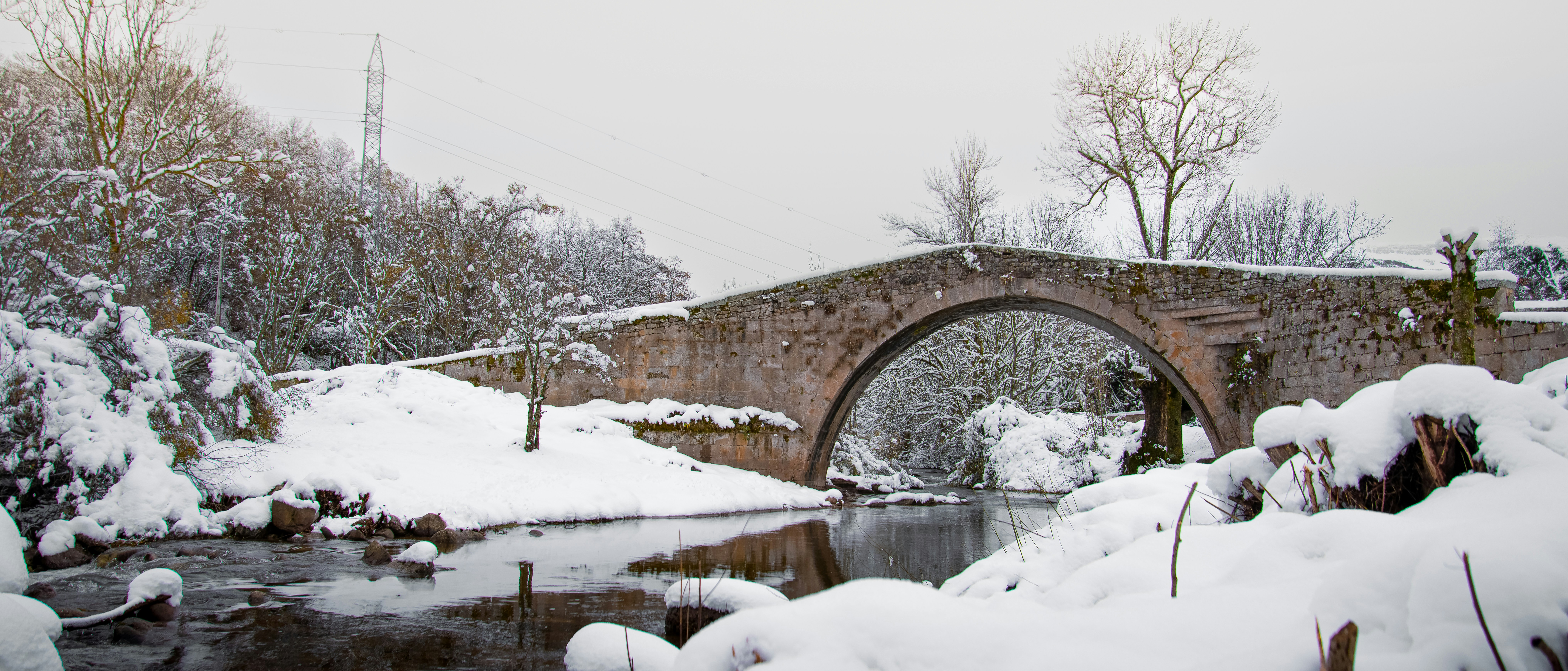 Stone bridge over a river in a snowy landscape