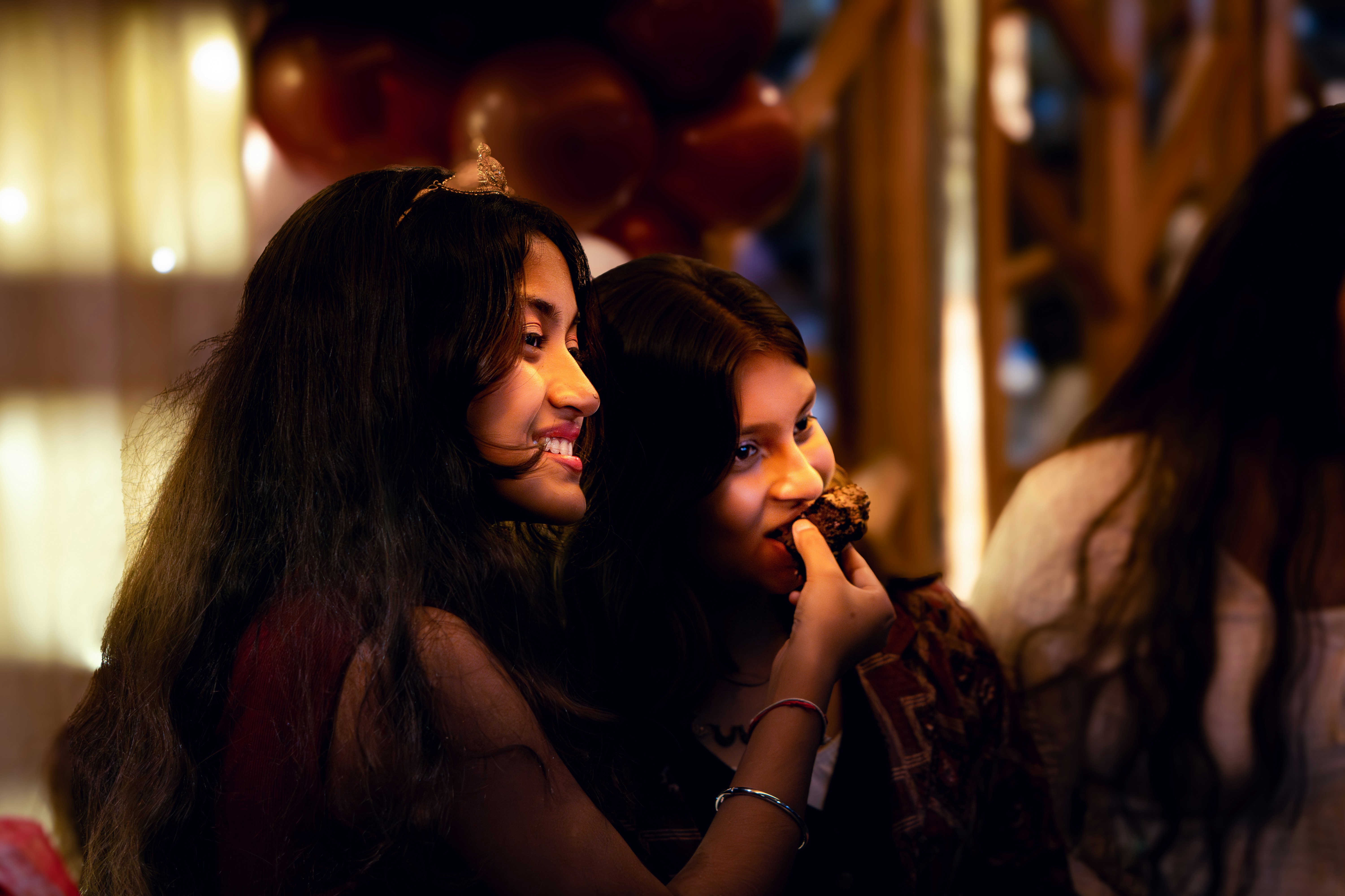Two young women sharing cake at a party