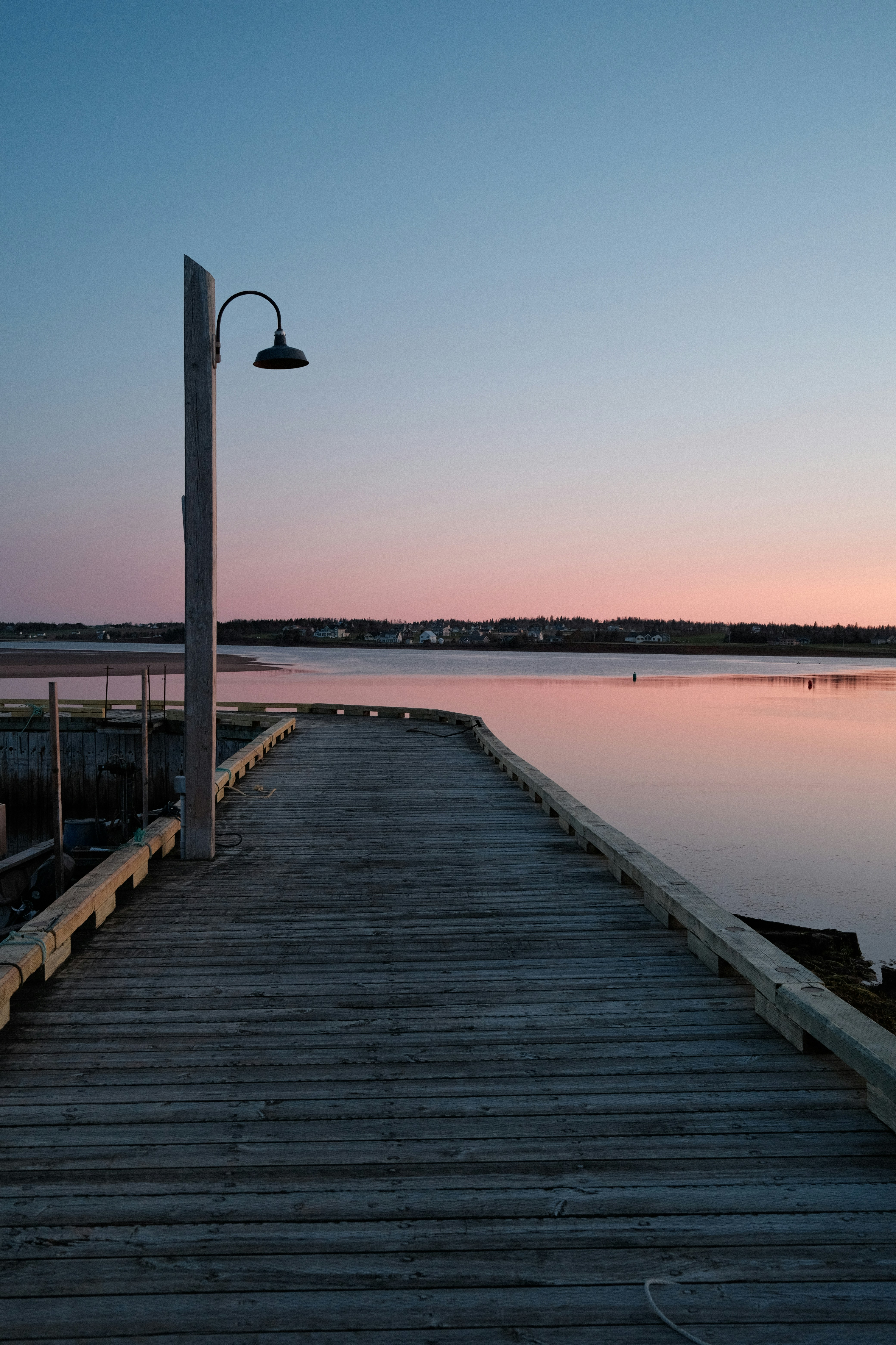 Wooden pier on calm water at sunset