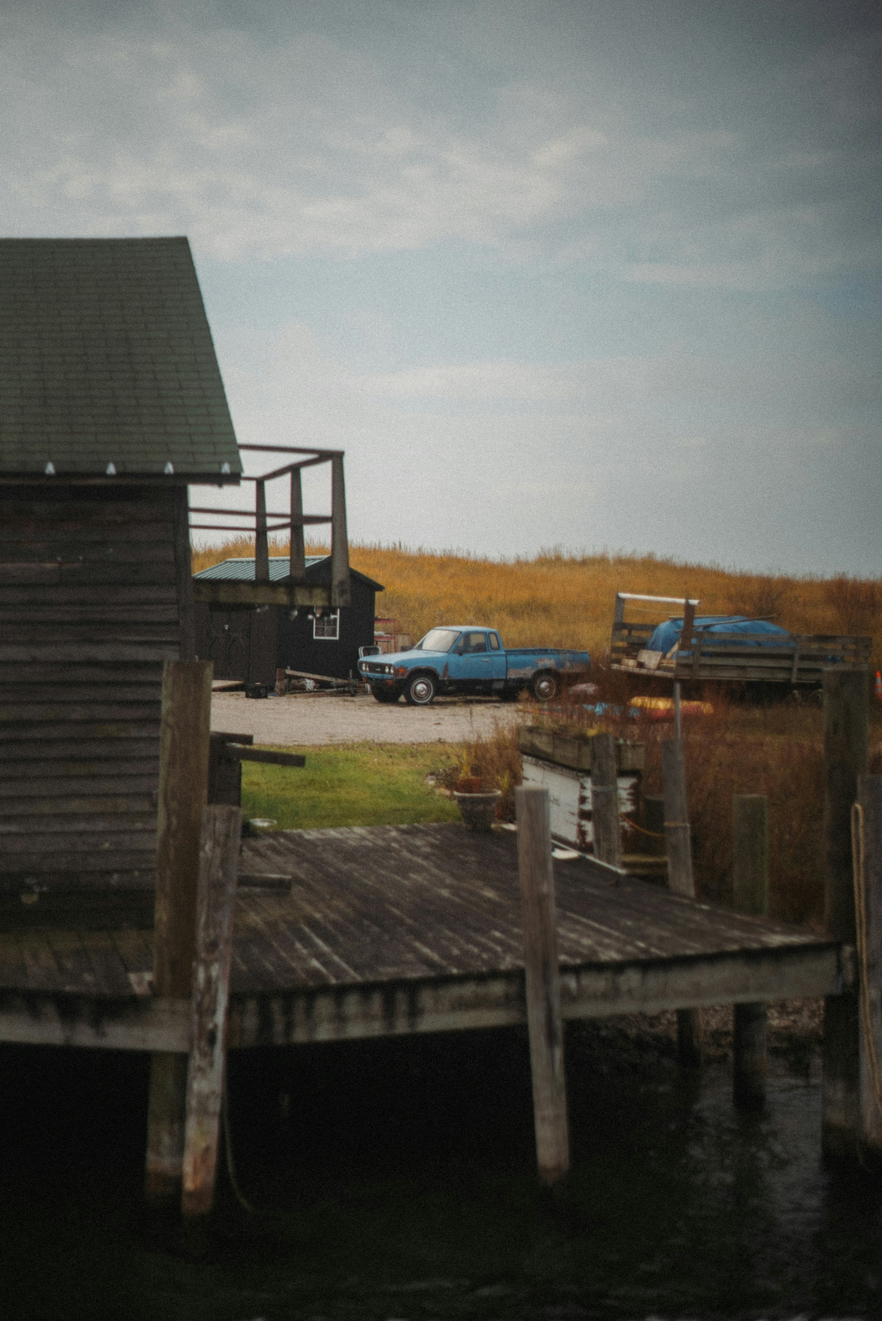 Blue pickup truck parked near a wooden dock