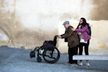 Young woman helps elderly man in wheelchair