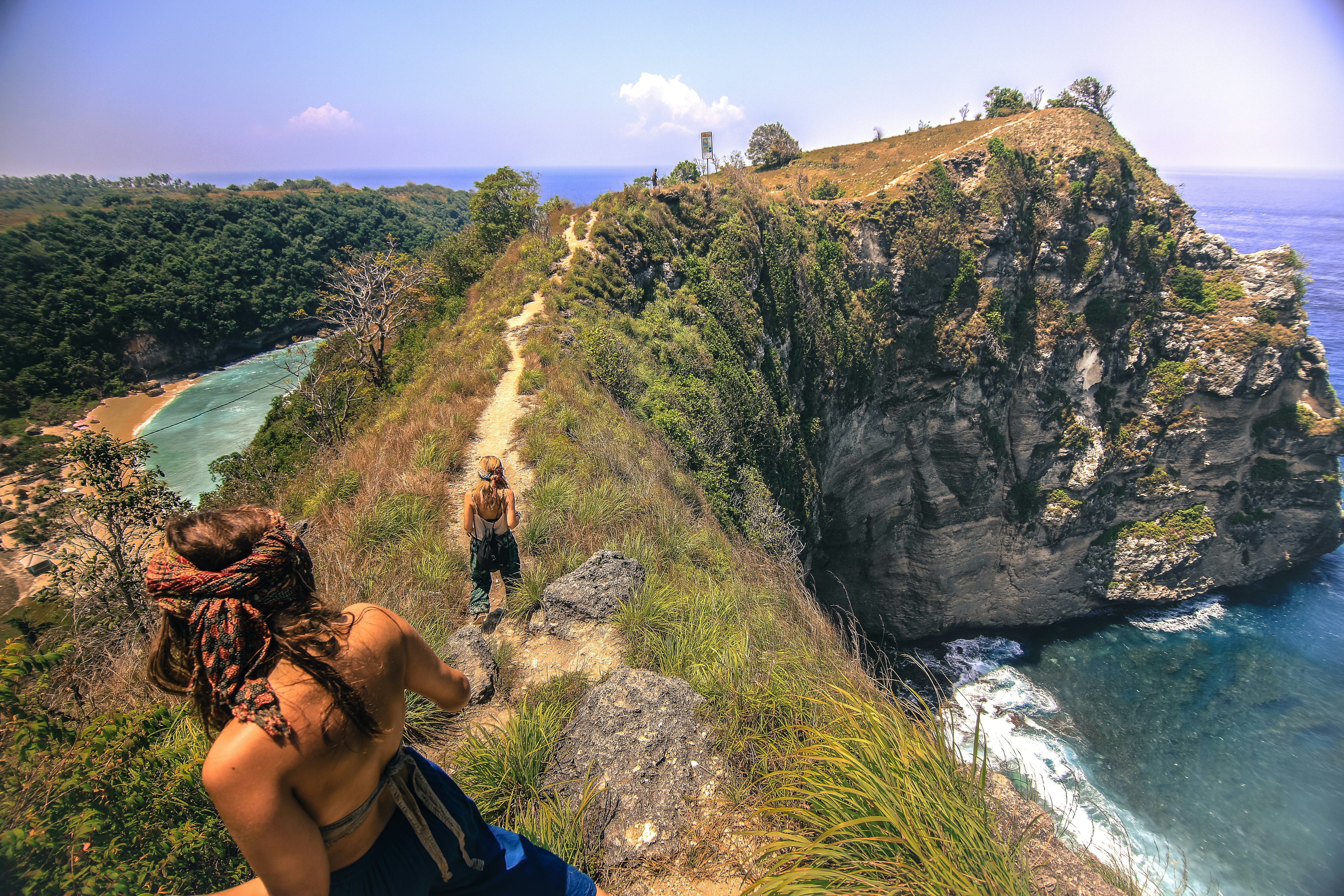 Two hikers on a cliff overlooking the ocean