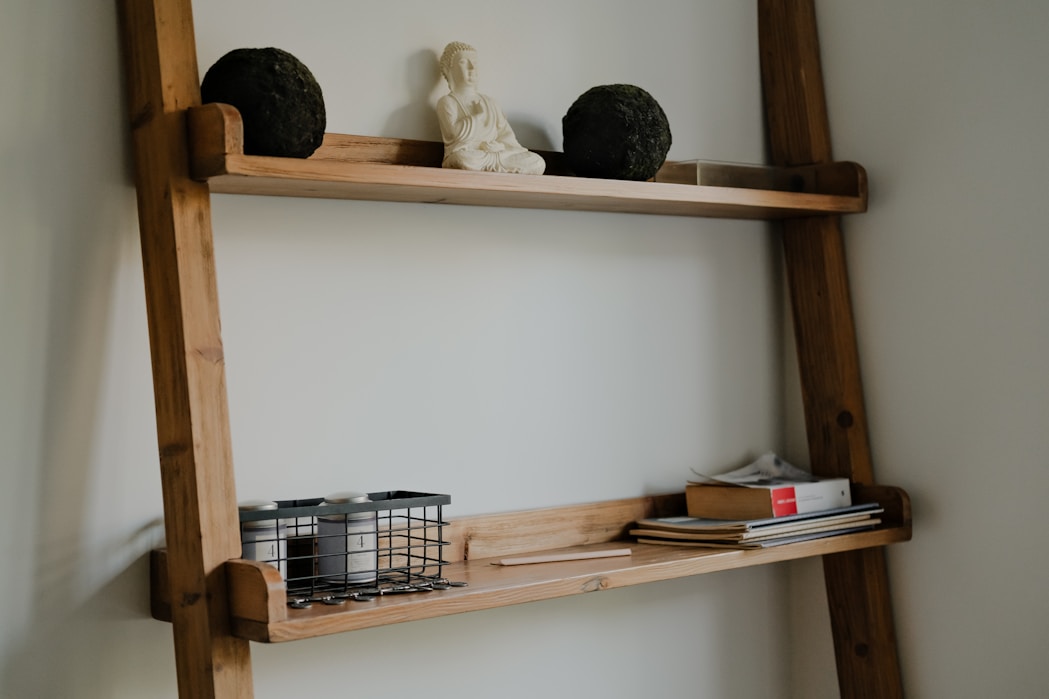 Wooden ladder shelf with decorative items and books.