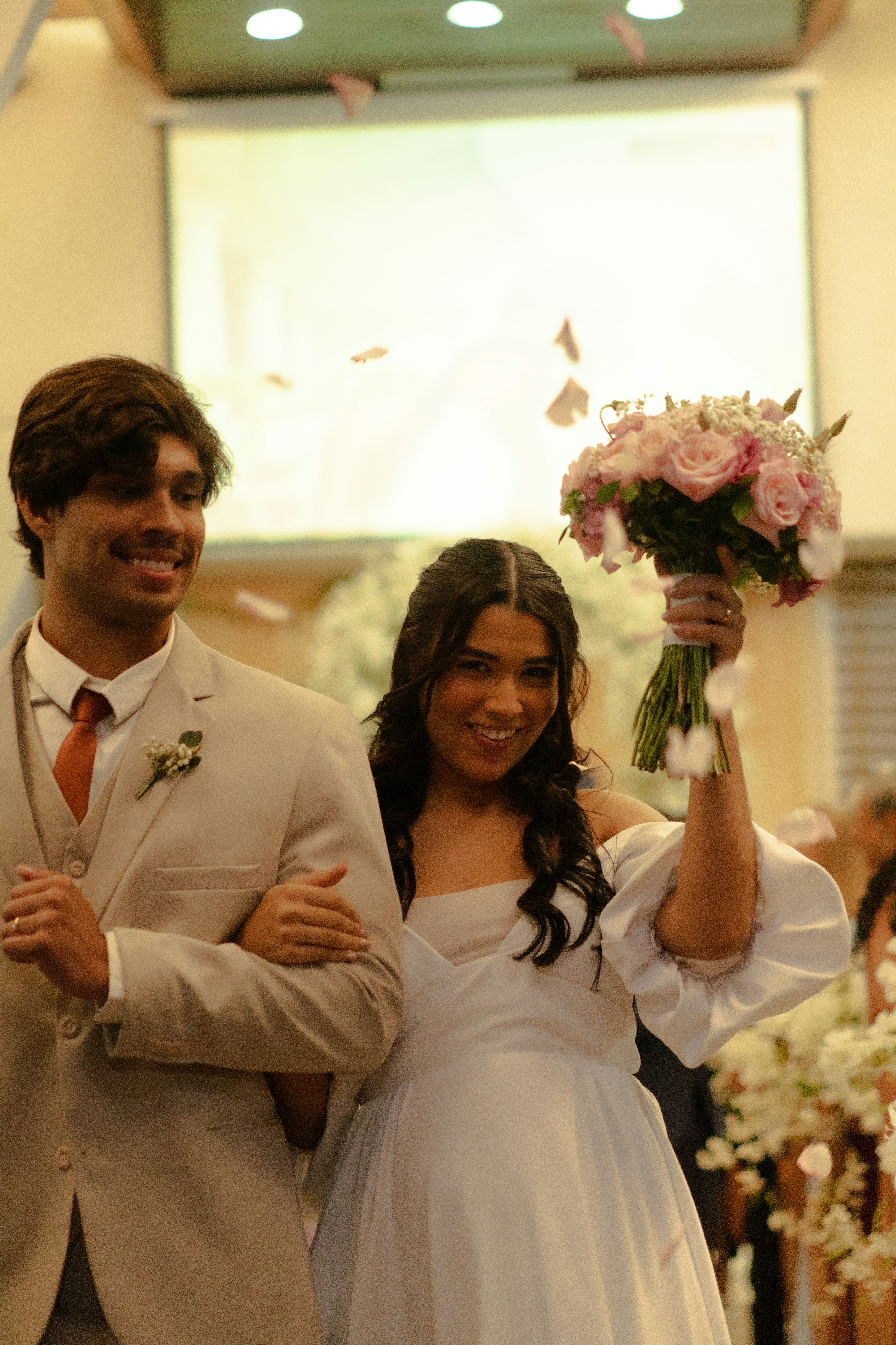Newlyweds walk down aisle with rose petals falling