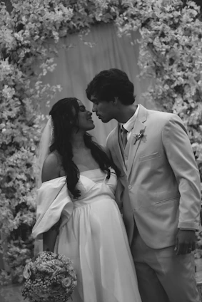 Bride and groom kissing under floral arch