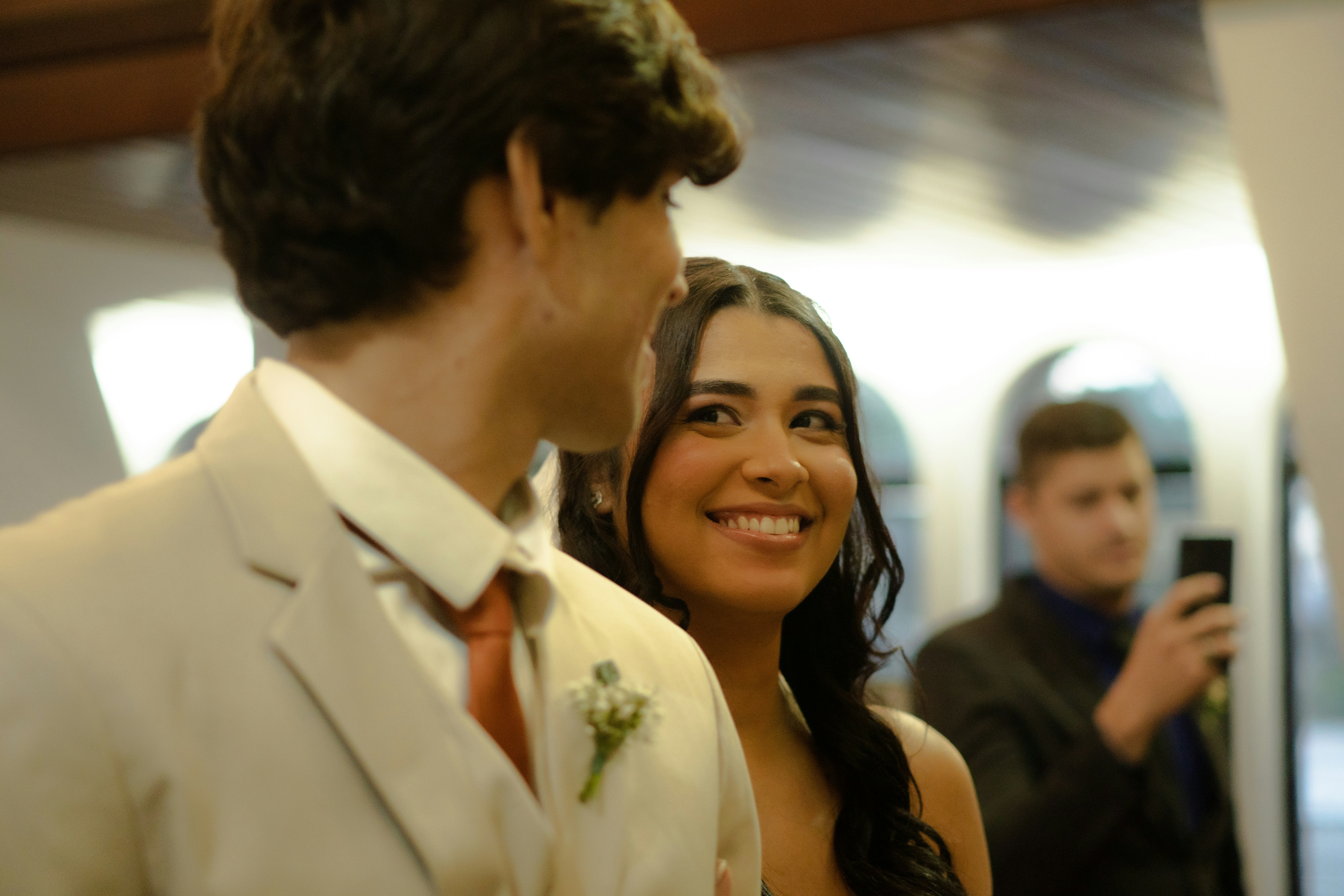 A smiling woman looks at a man in a suit