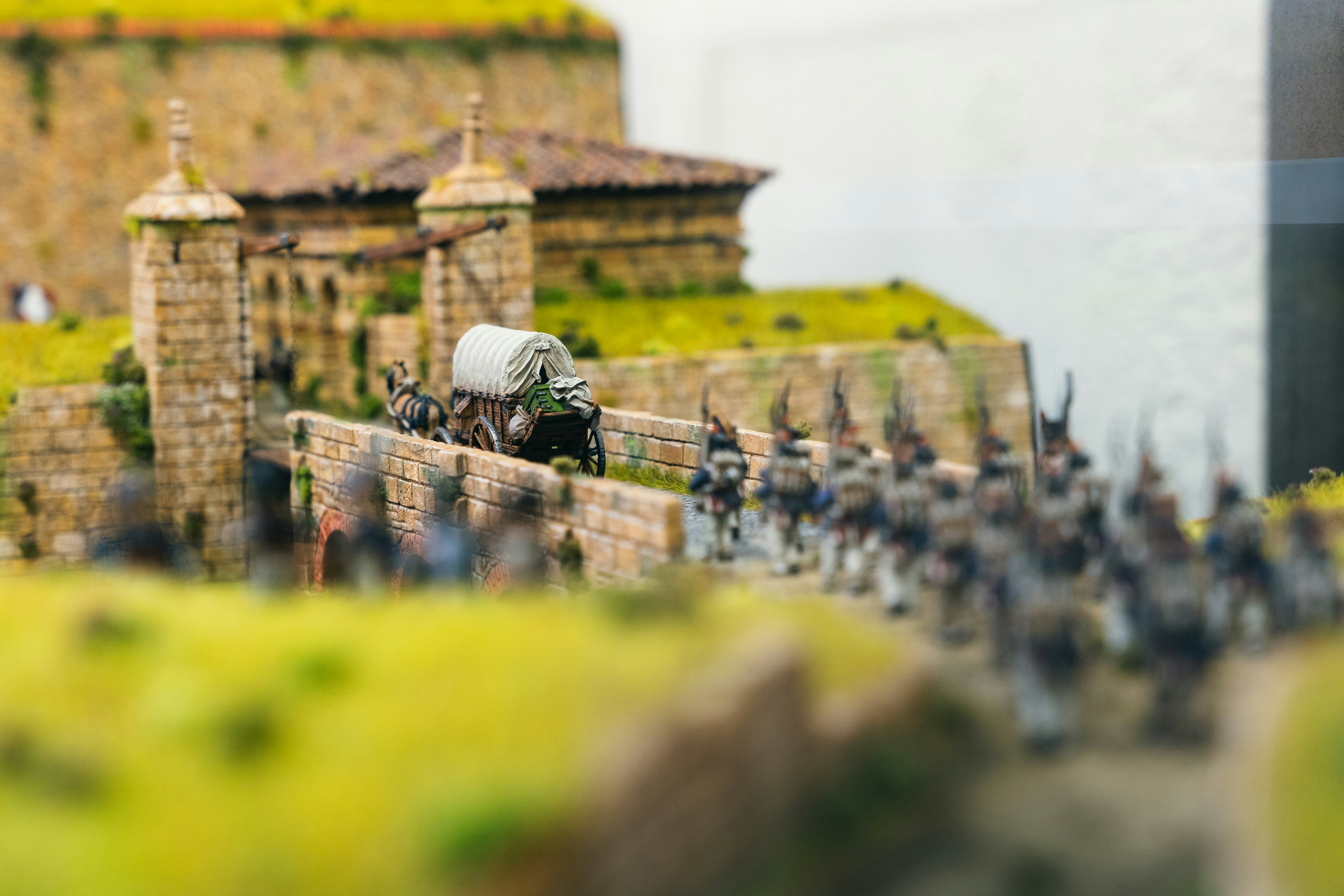 Miniature soldiers march past a stone fort