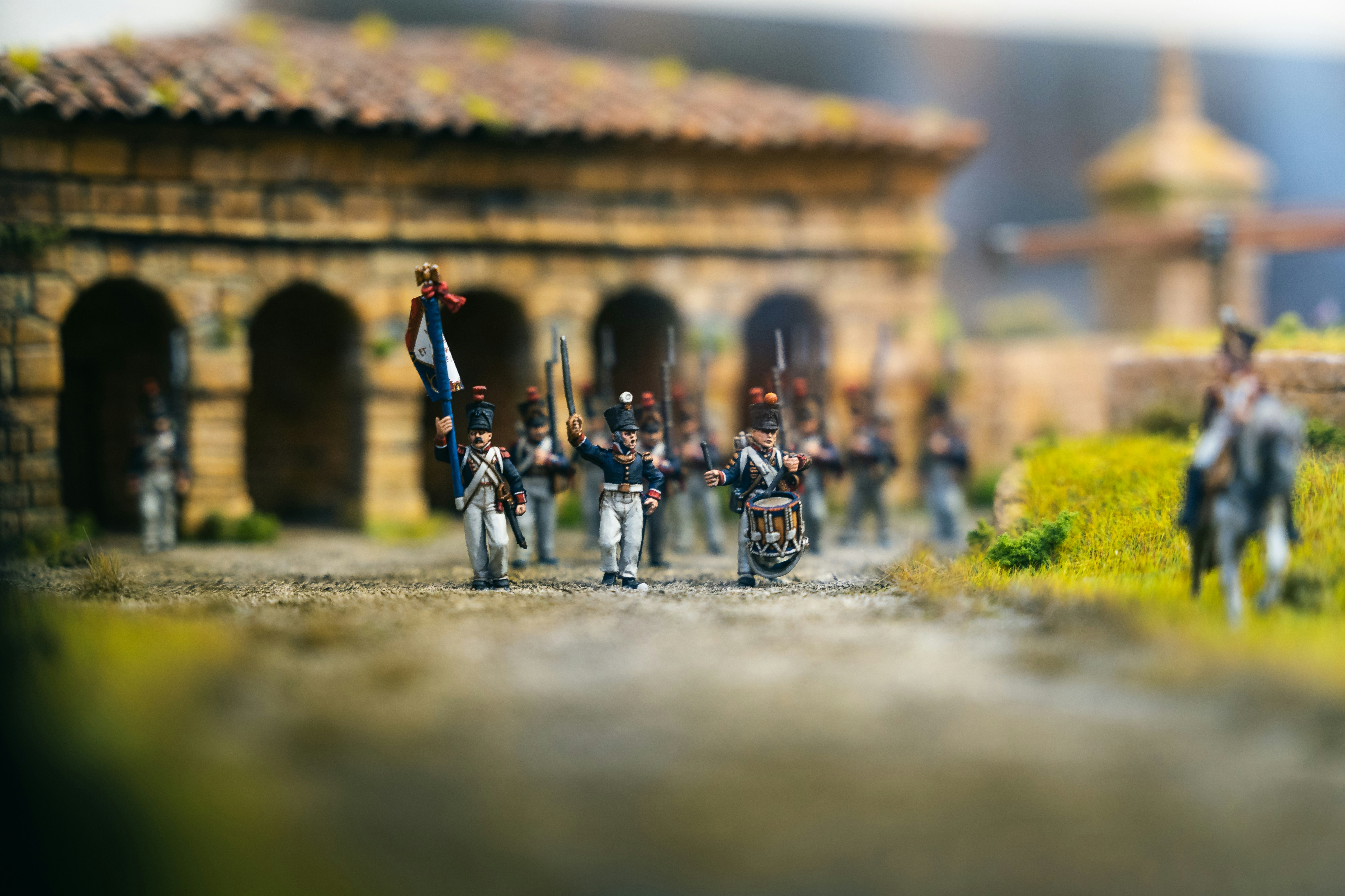 Miniature soldiers in uniform marching with flags.