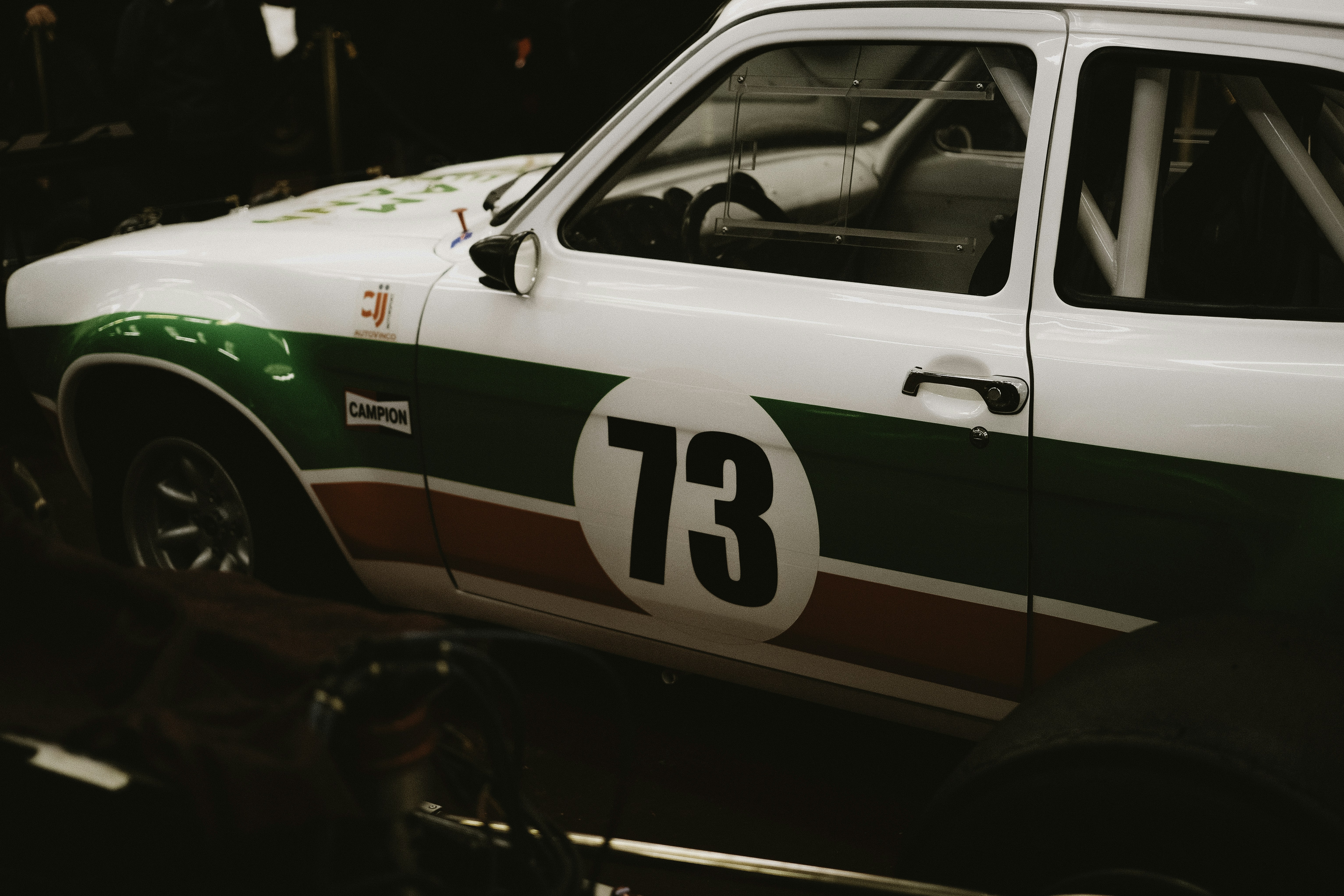 White race car with green and red stripes, number 73