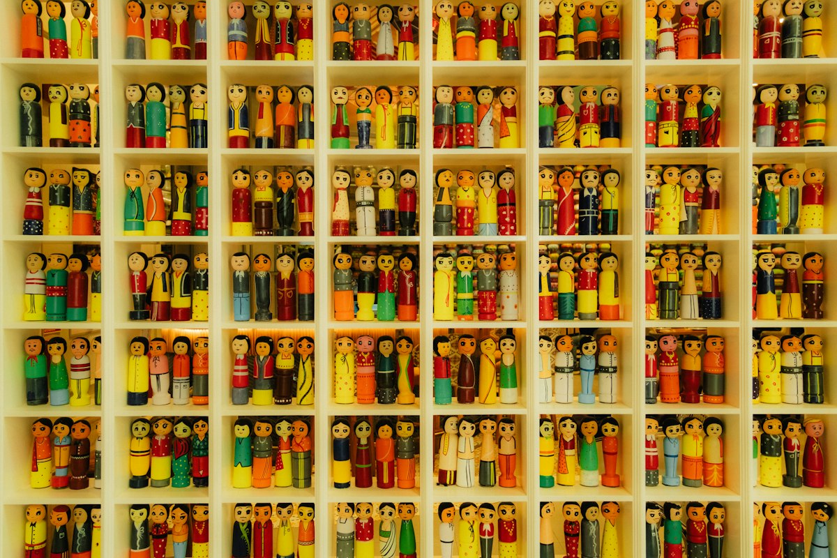 Rows of colorful wooden peg dolls on shop shelves