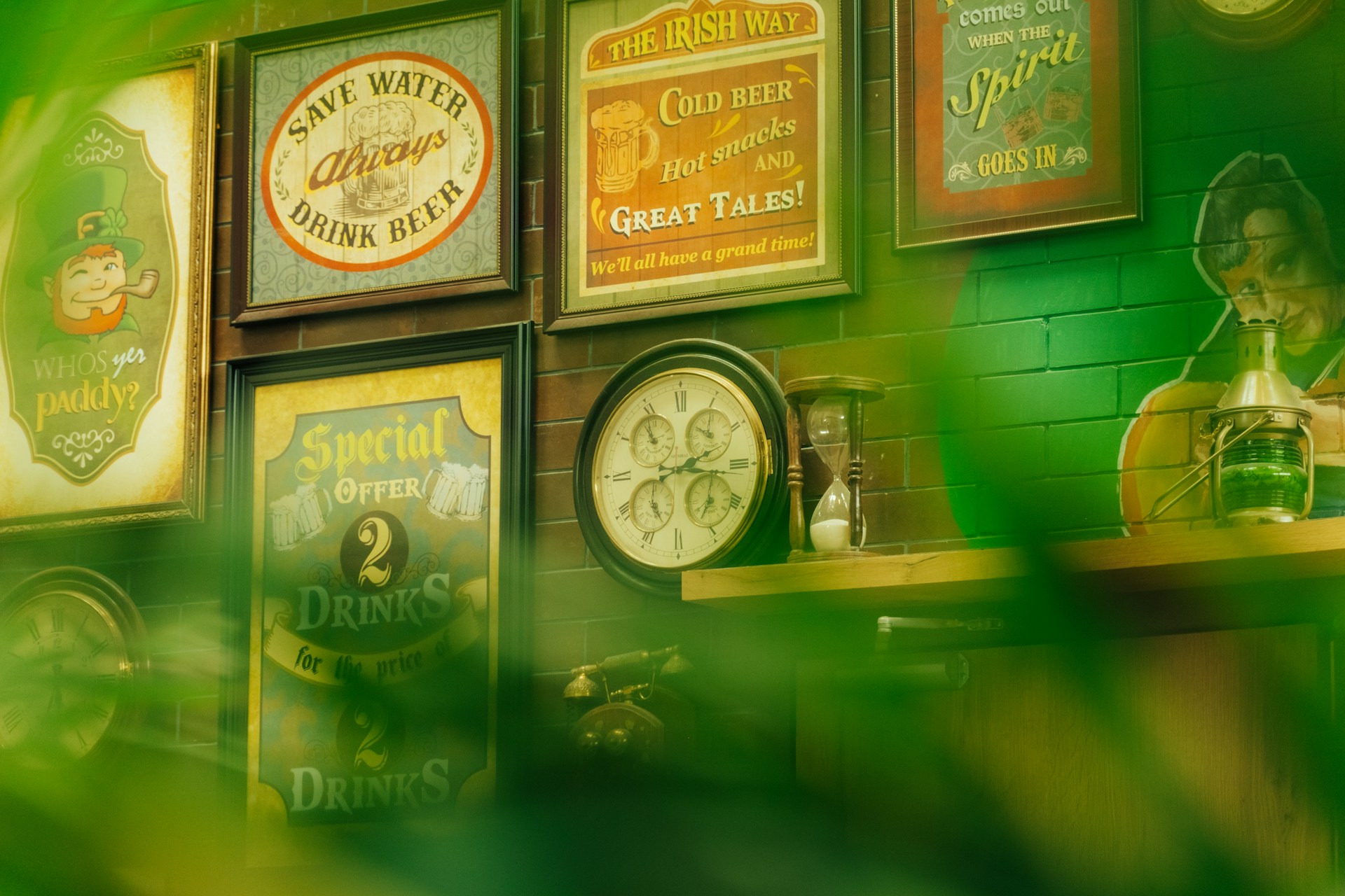 Vintage irish pub decor with framed advertisements and clock.
