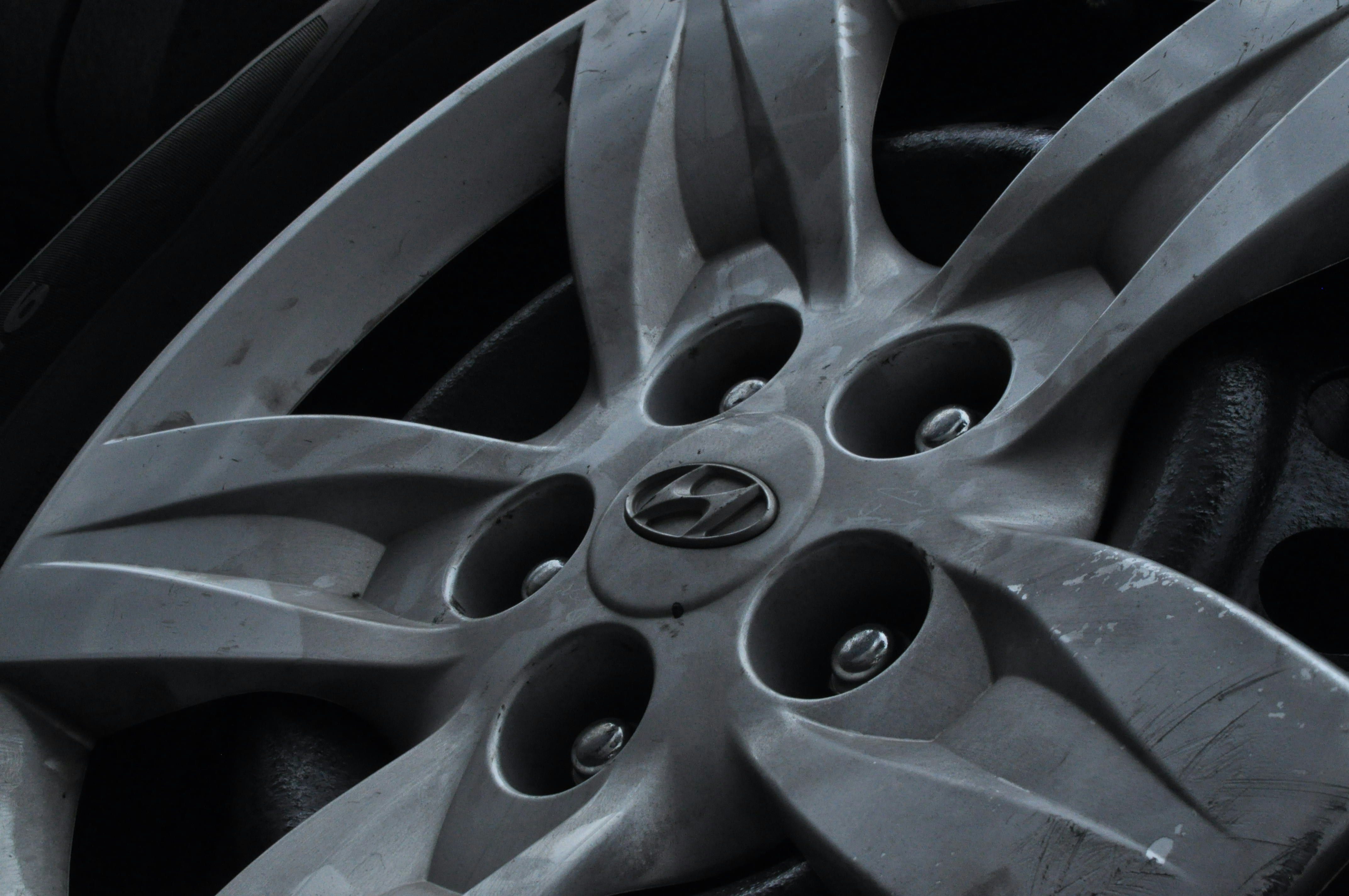 Close-up of a silver car wheel hubcap with five spokes